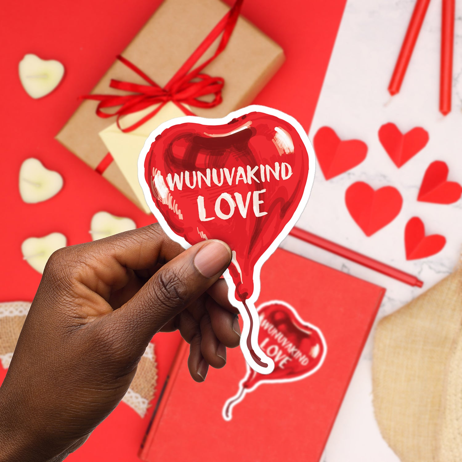 a person holding up a heart shaped sticker