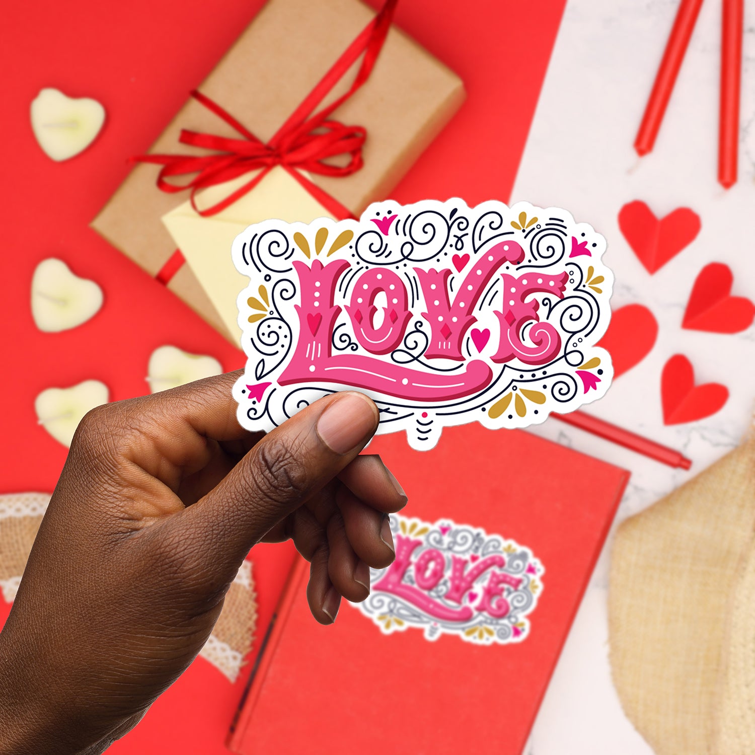 a hand holding a sticker with the word love on it
