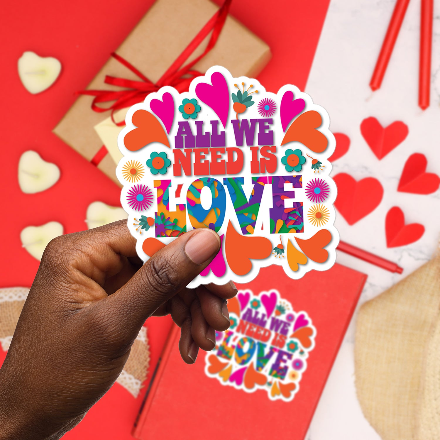 a hand holding a sticker that says all we need is love