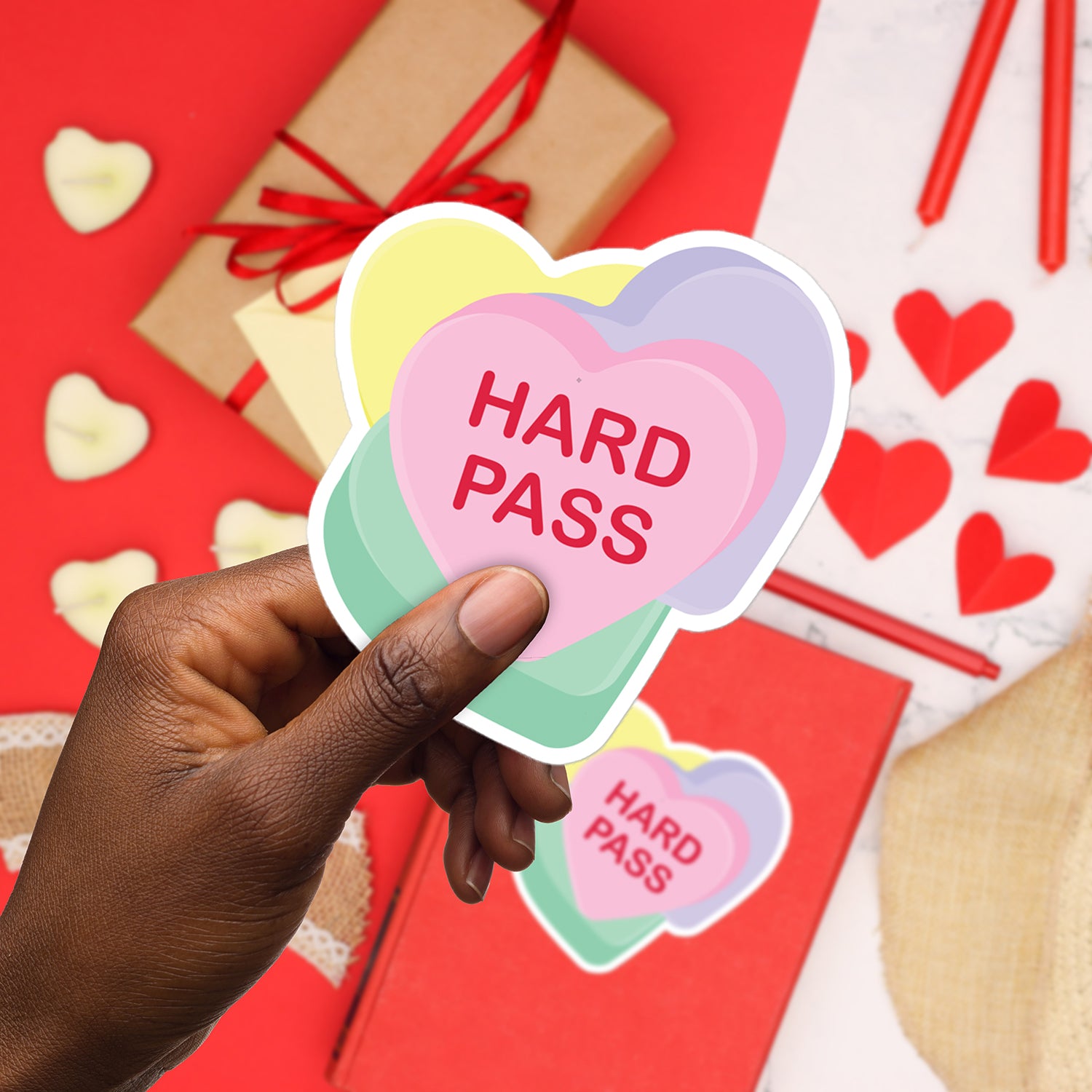 a hand holding a heart shaped sticker that says hard pass