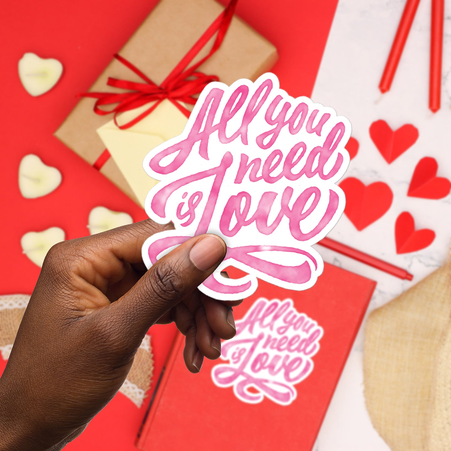 a hand holding a sticker that says, all you need is love