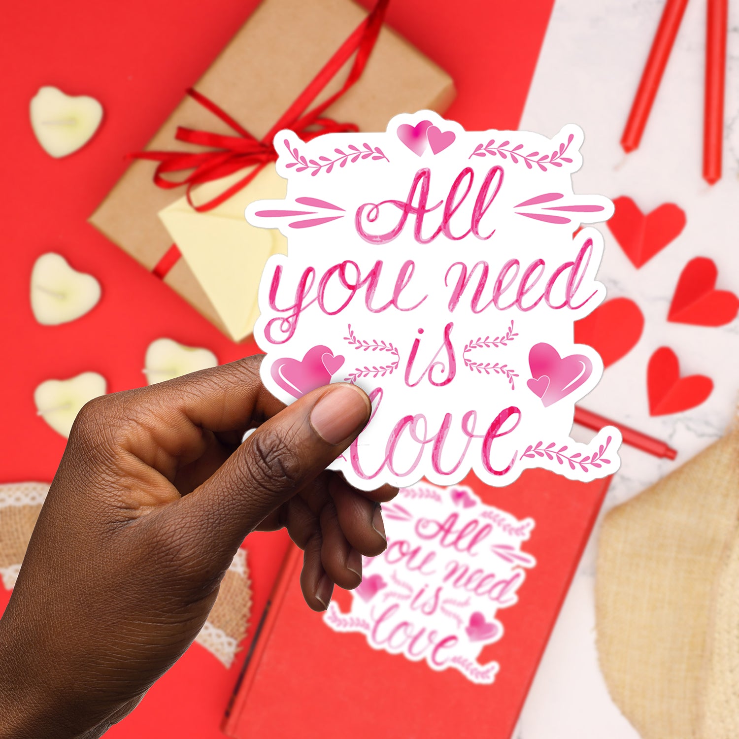 a hand holding a sticker that says all you need is love