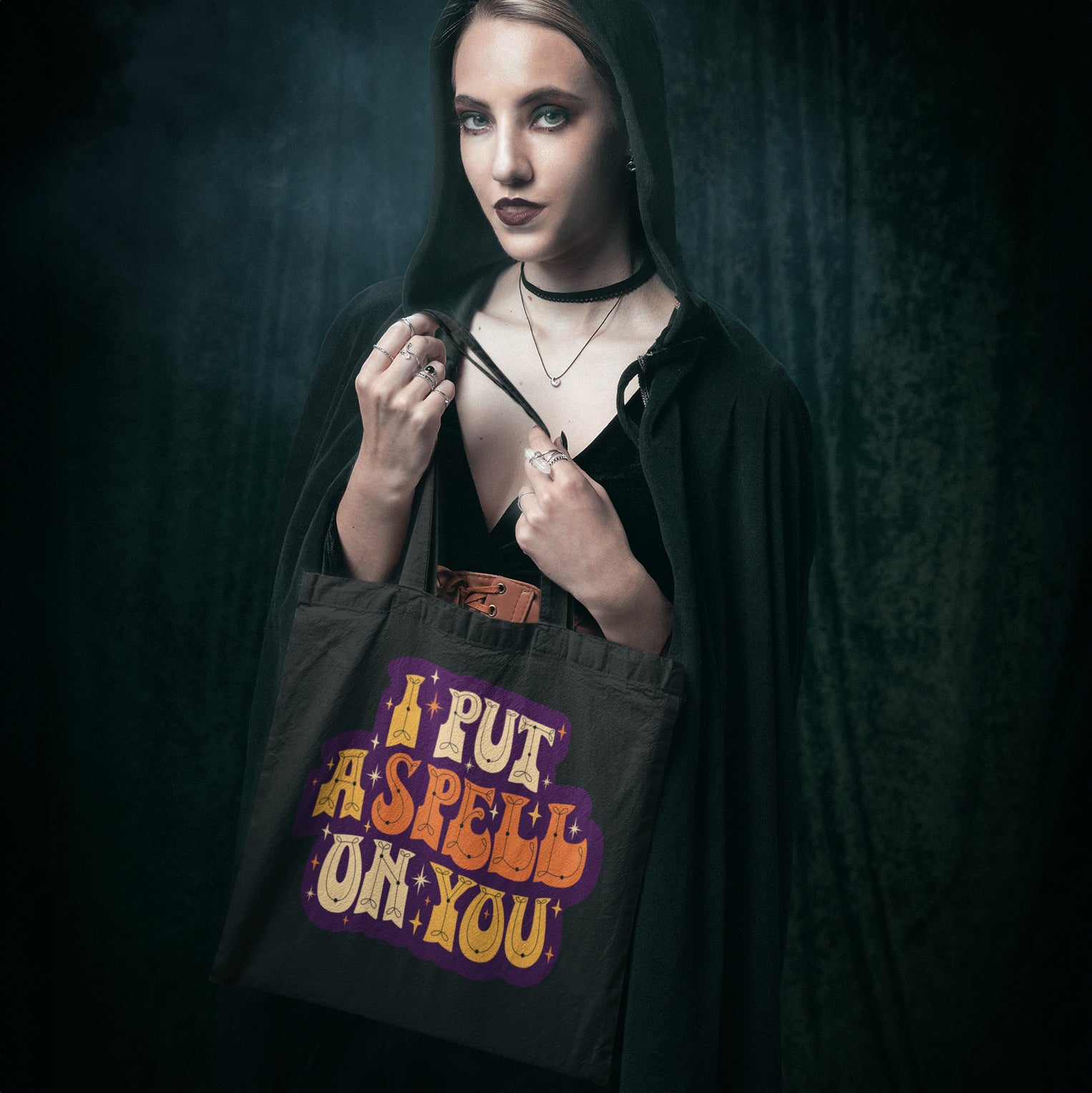 a woman holding a black bag that says i put a spell on you