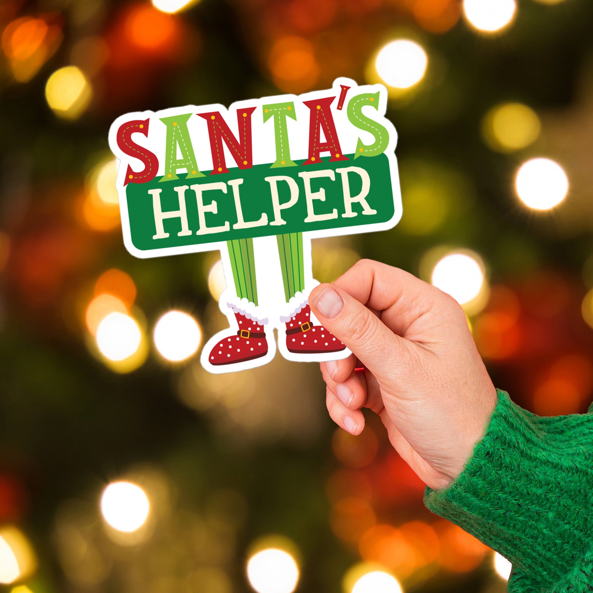 a person holding up a sticker that says santa's helper