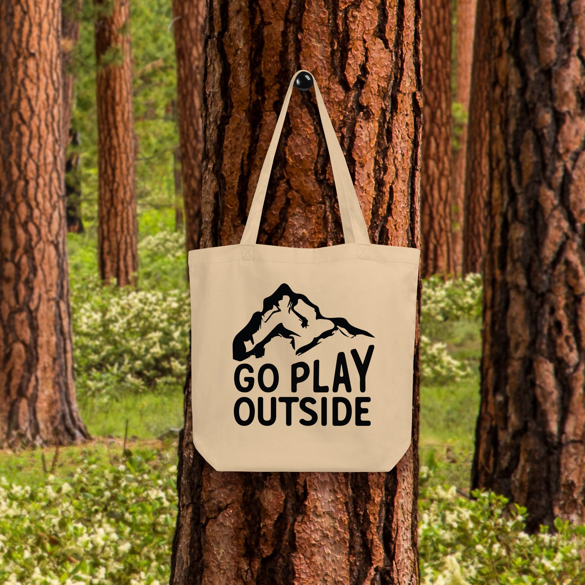 a tote bag hanging on a tree in a forest