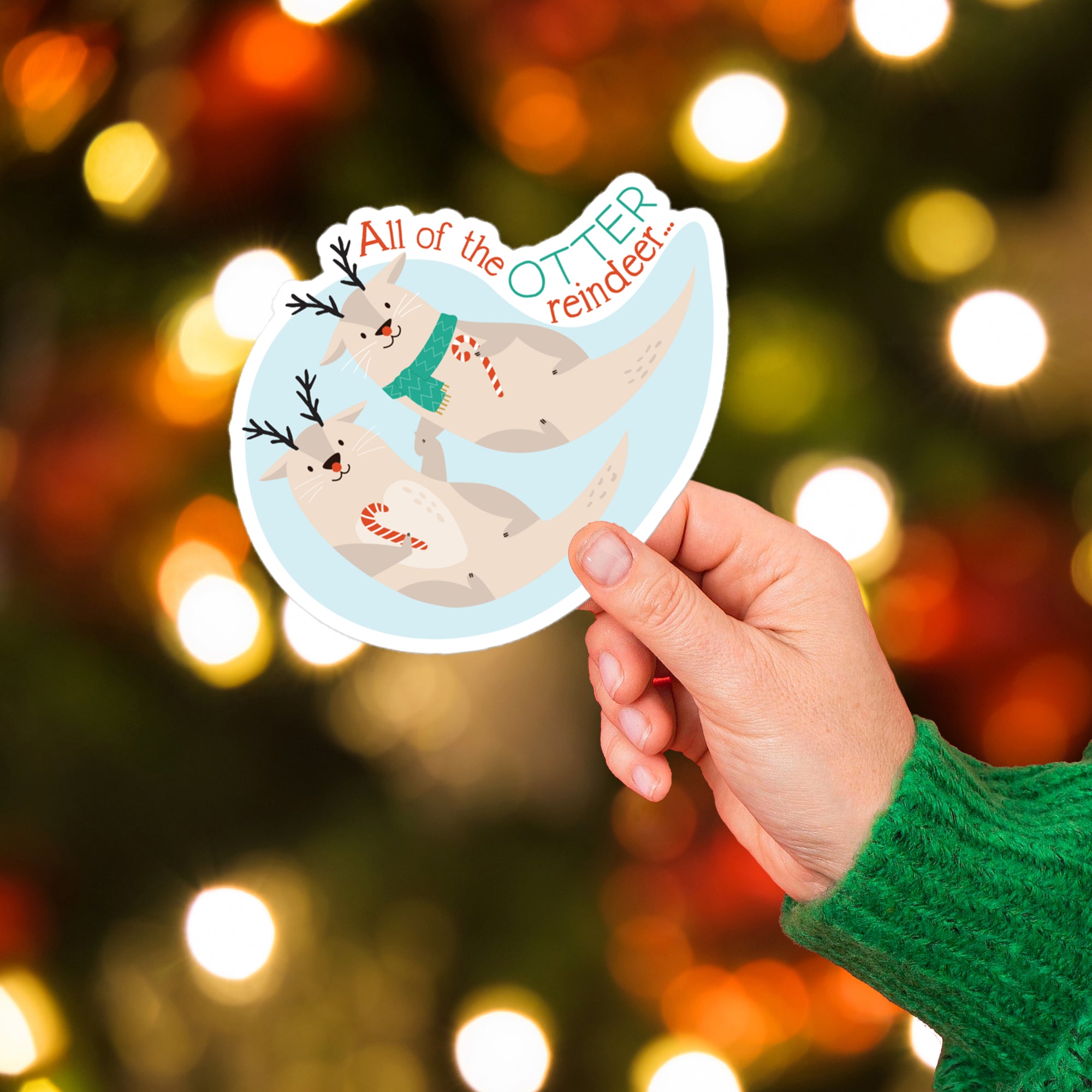 a person holding up a sticker with reindeers on it