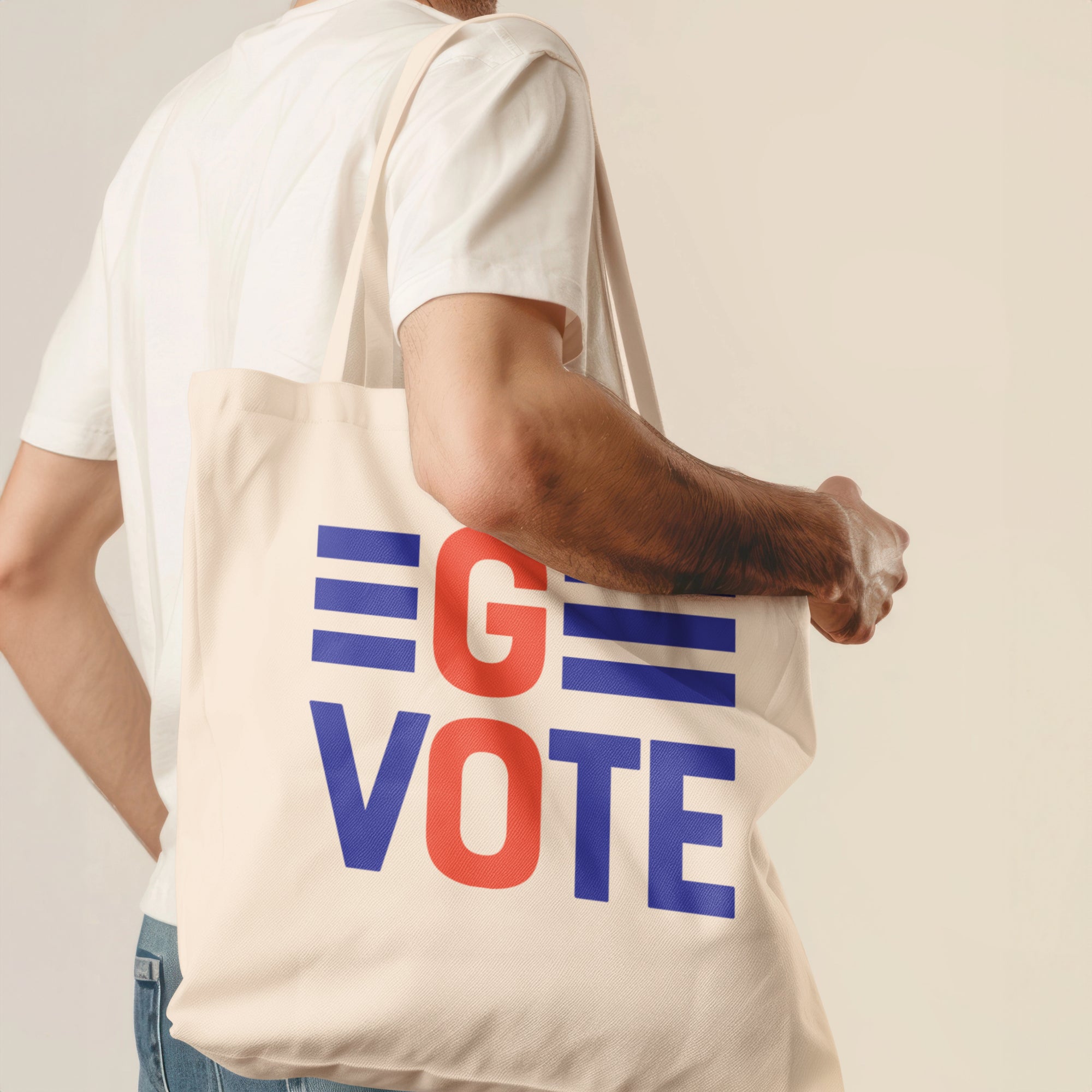 a man holding a tote bag with the word vote printed on it