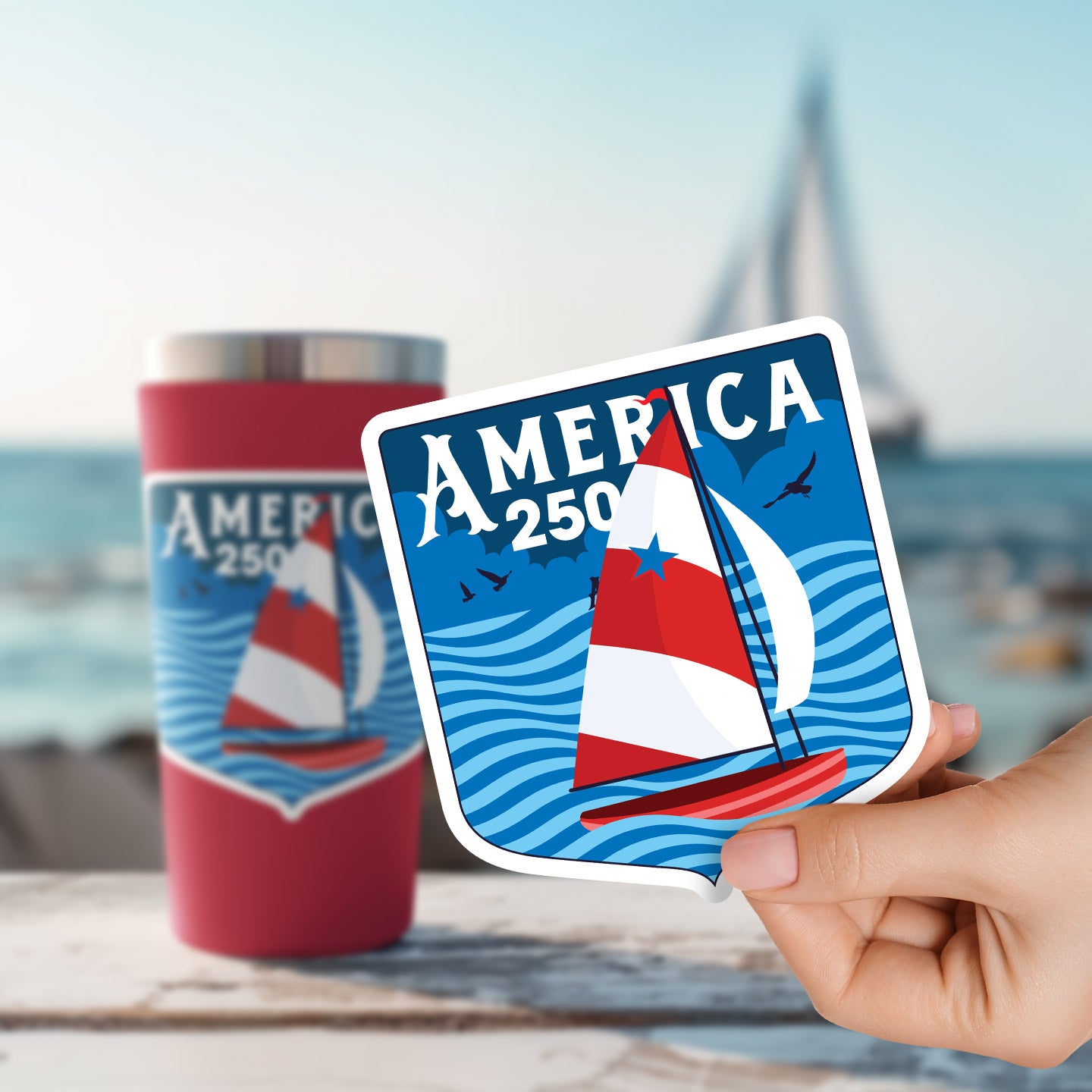 a hand holding a sticker with a picture of a sailboat