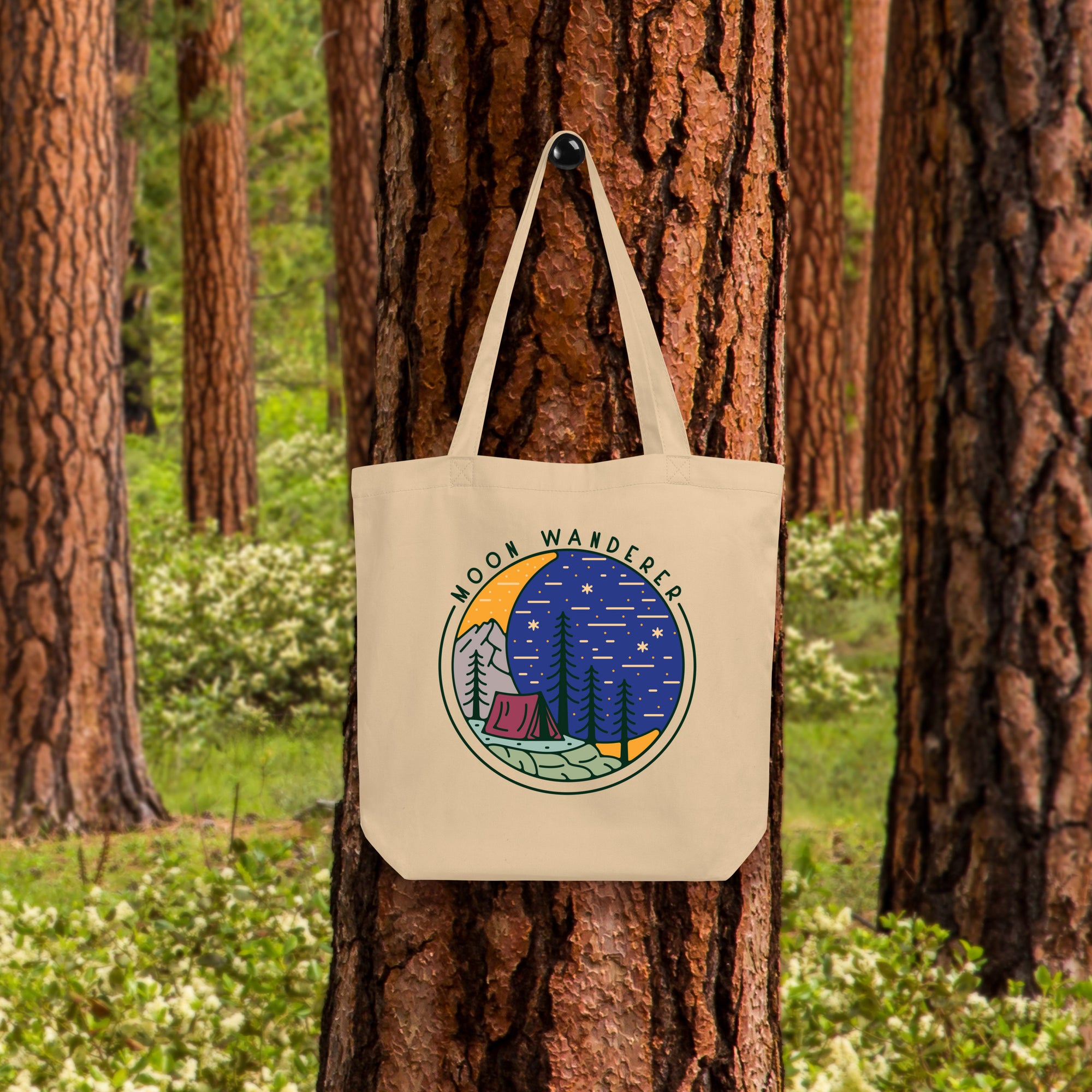 a tote bag hanging on a tree in a forest