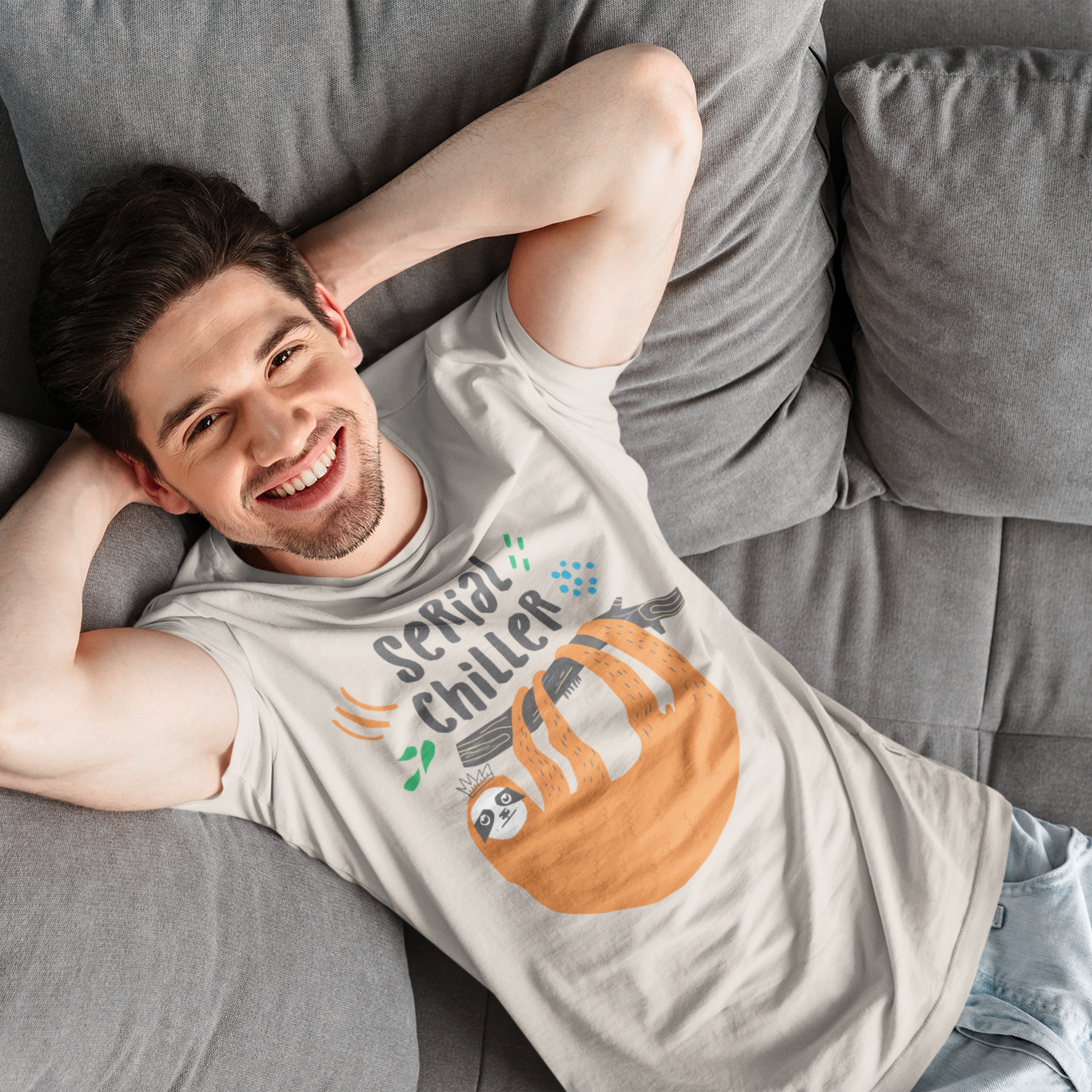 a man laying on top of a gray couch