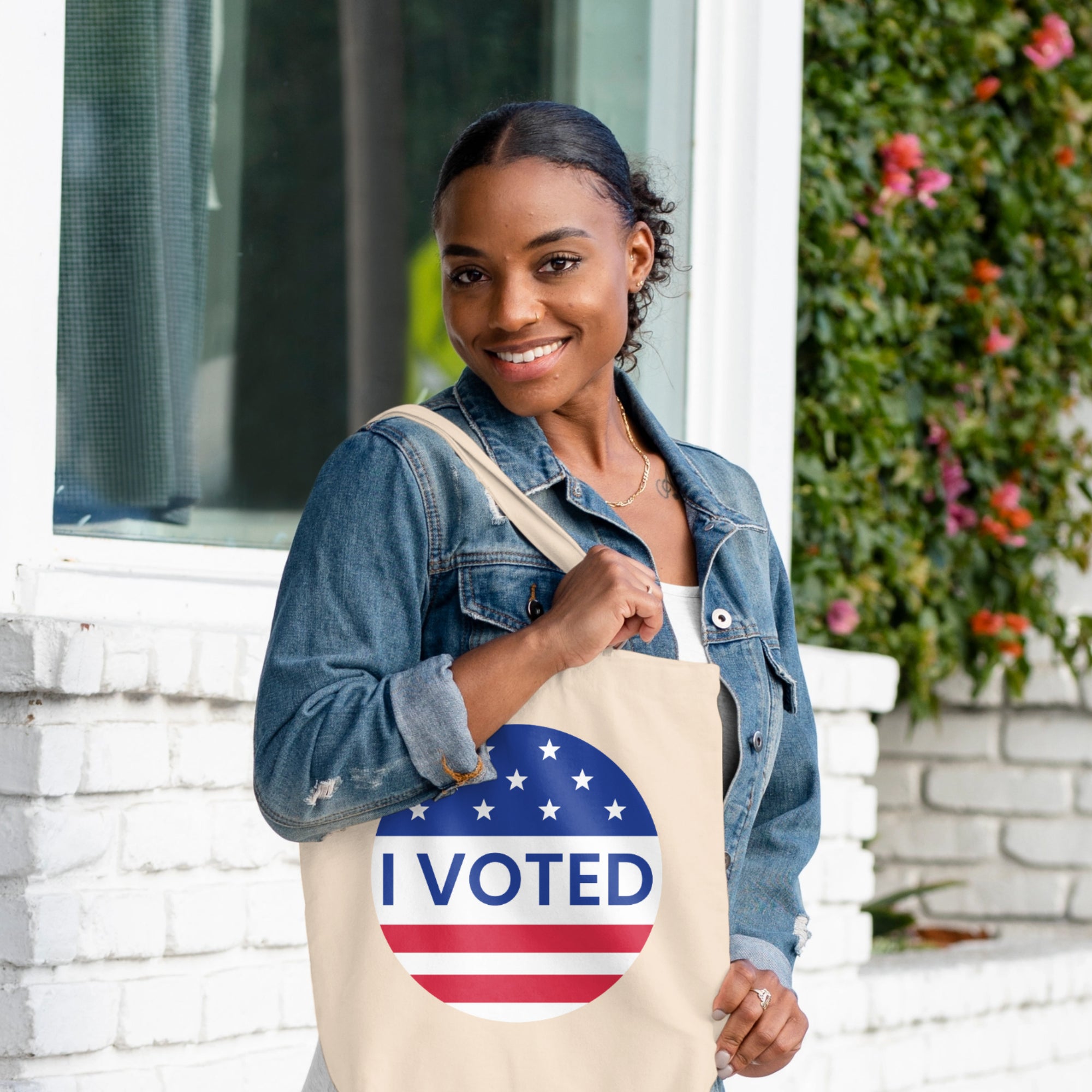 a woman holding a tote bag that says i vote