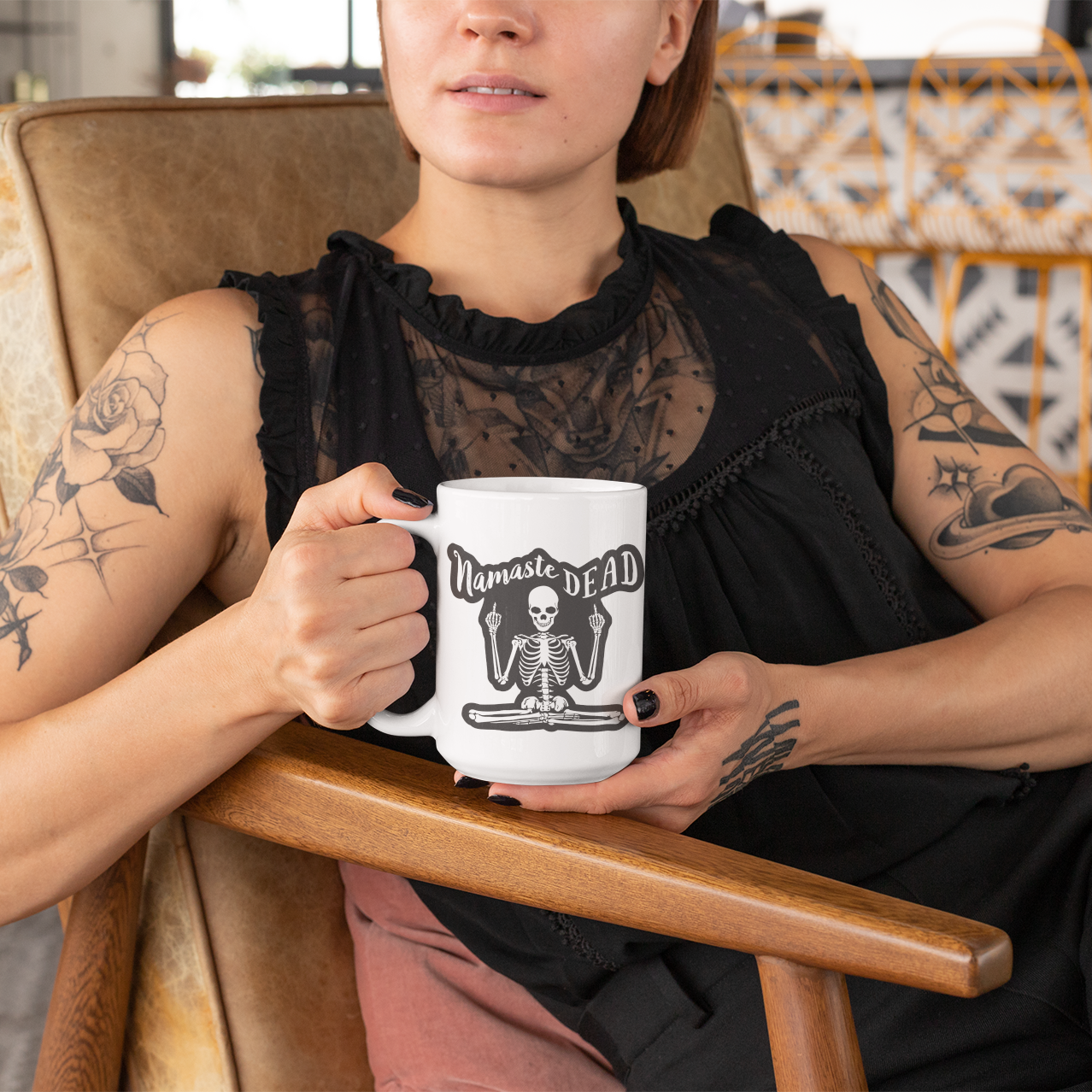 a woman sitting in a chair holding a coffee mug