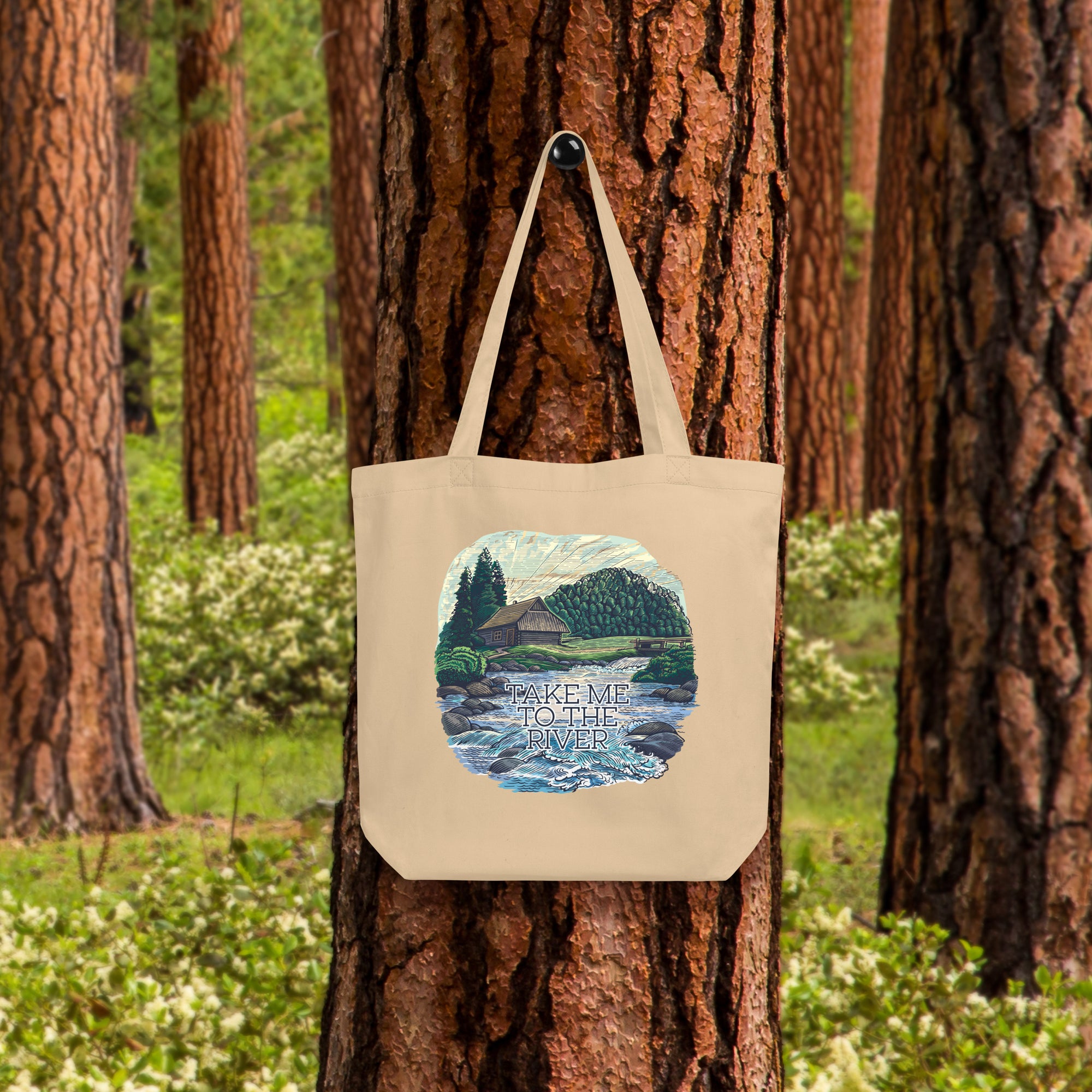 a tote bag hanging on a tree in a forest