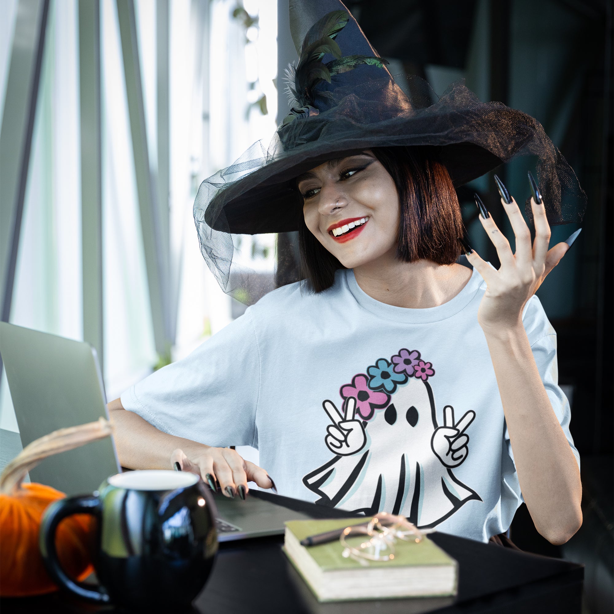 a woman wearing a witches hat sitting at a table