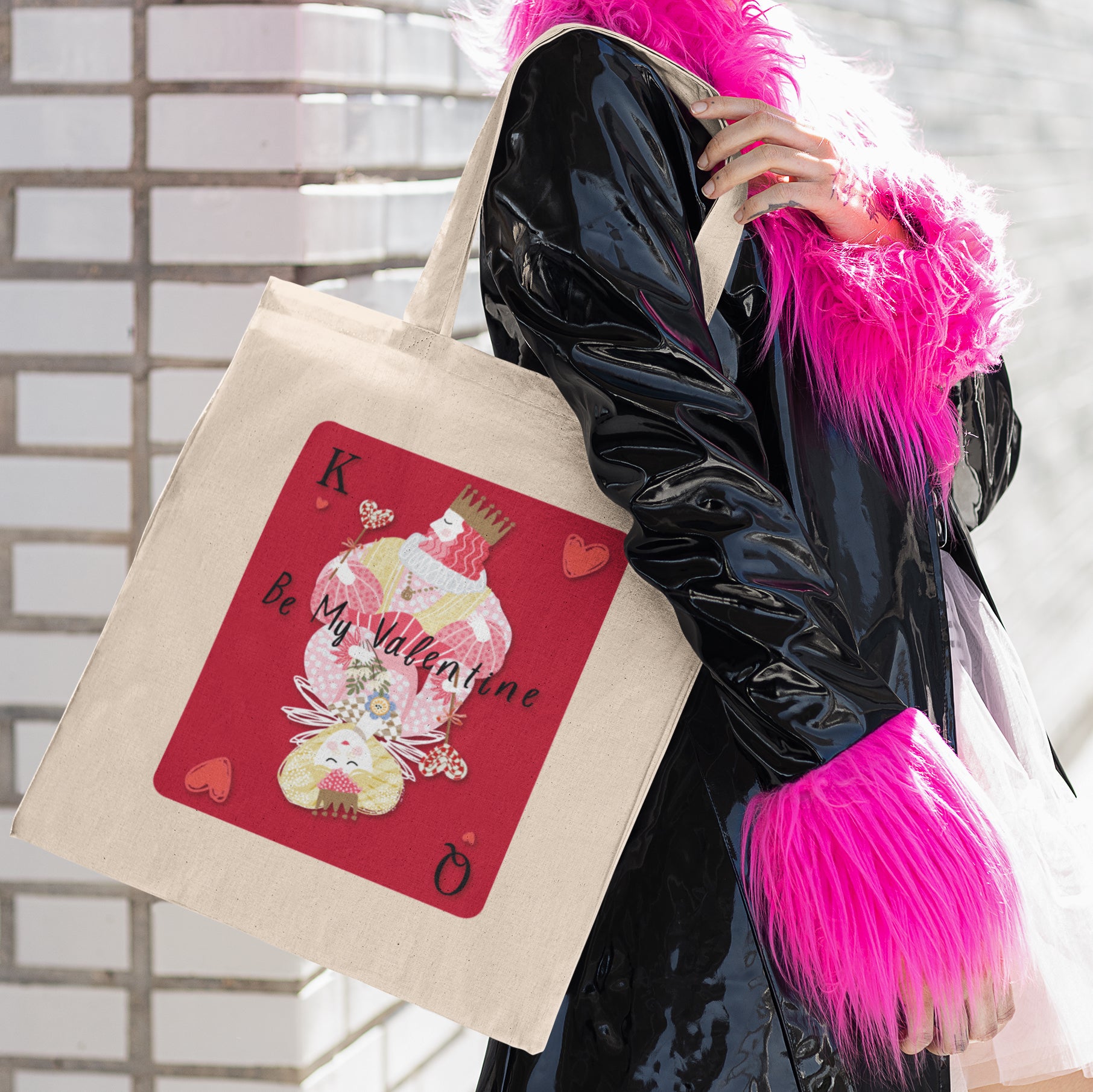 a woman in a black coat carrying a pink tote bag