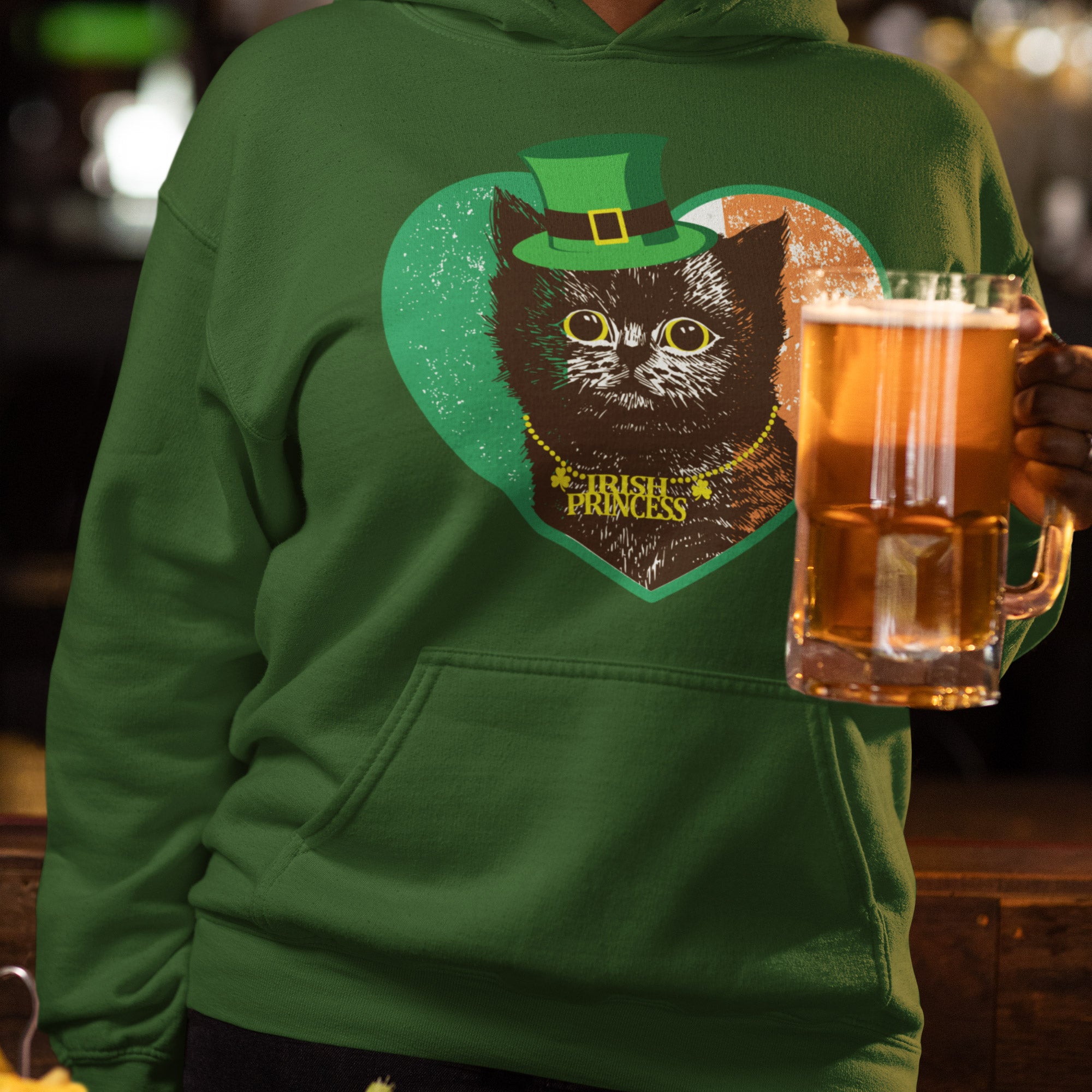 a man in a green hoodie holding a mug of beer