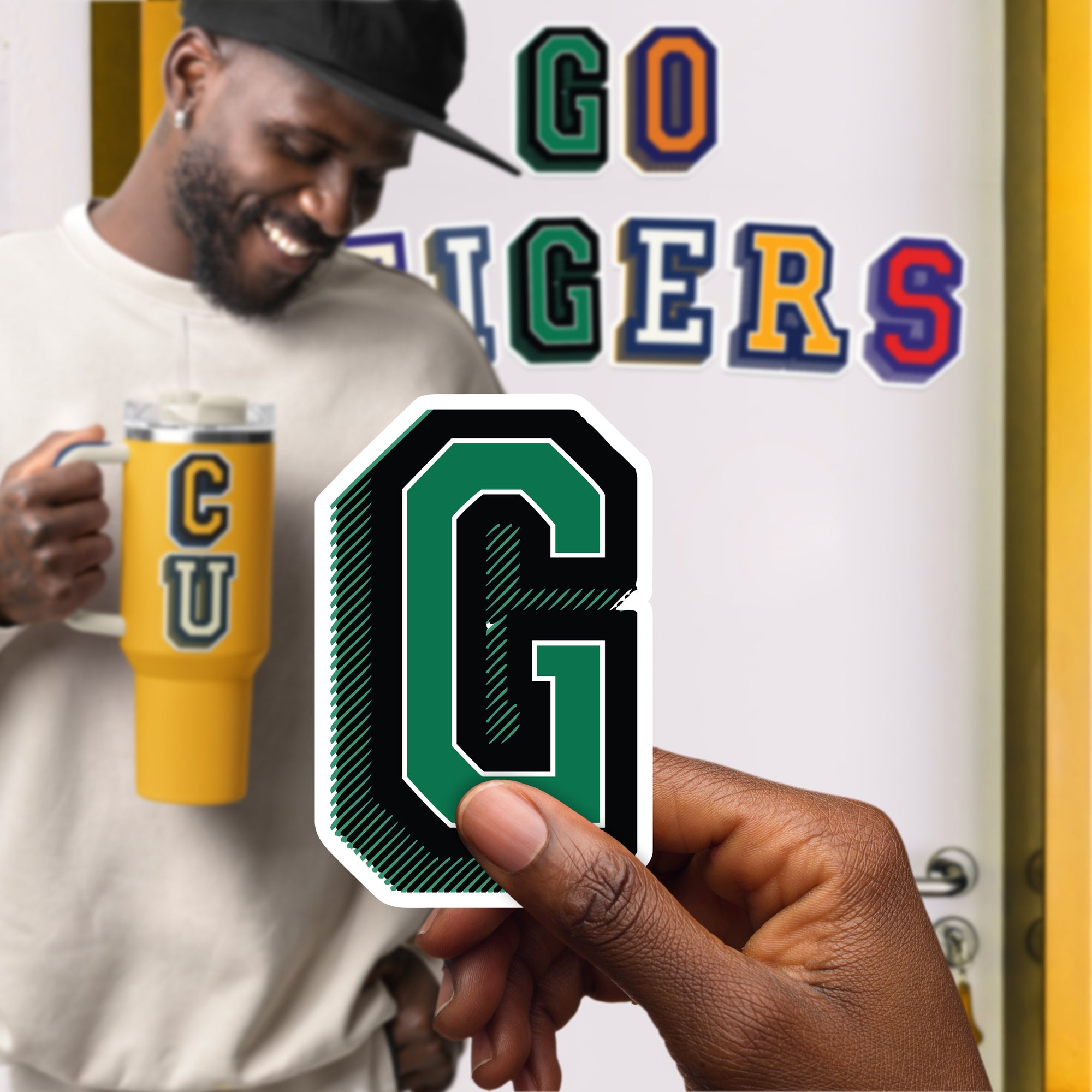 a man holding a cup of coffee with the letter g on it
