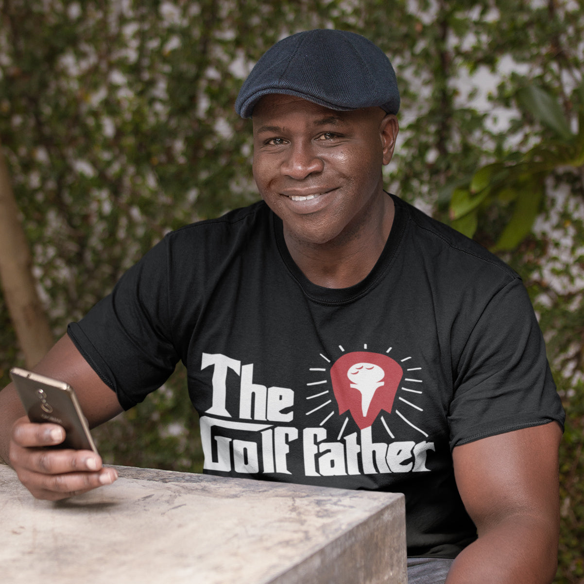 a man sitting at a table with a cell phone in his hand