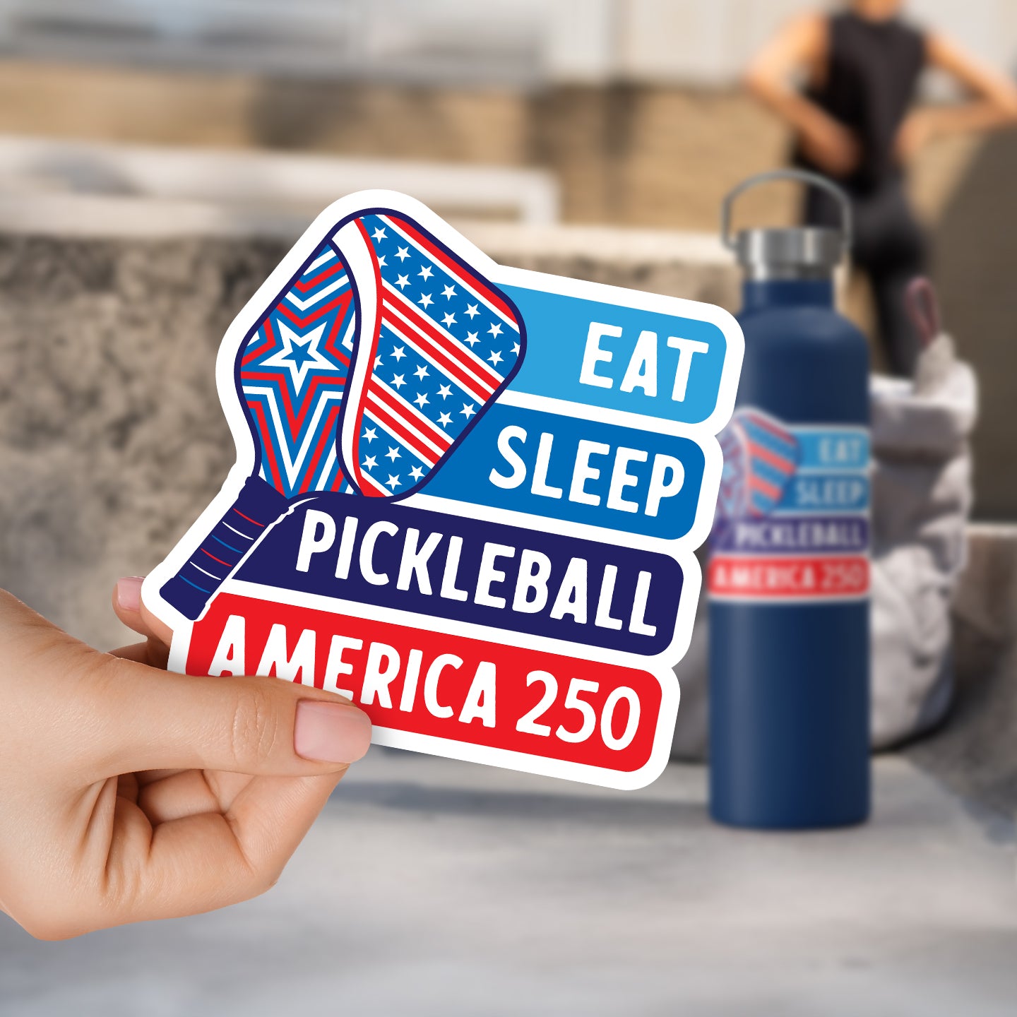 a person holding up a sticker that says eat sleep pickleball america 250
