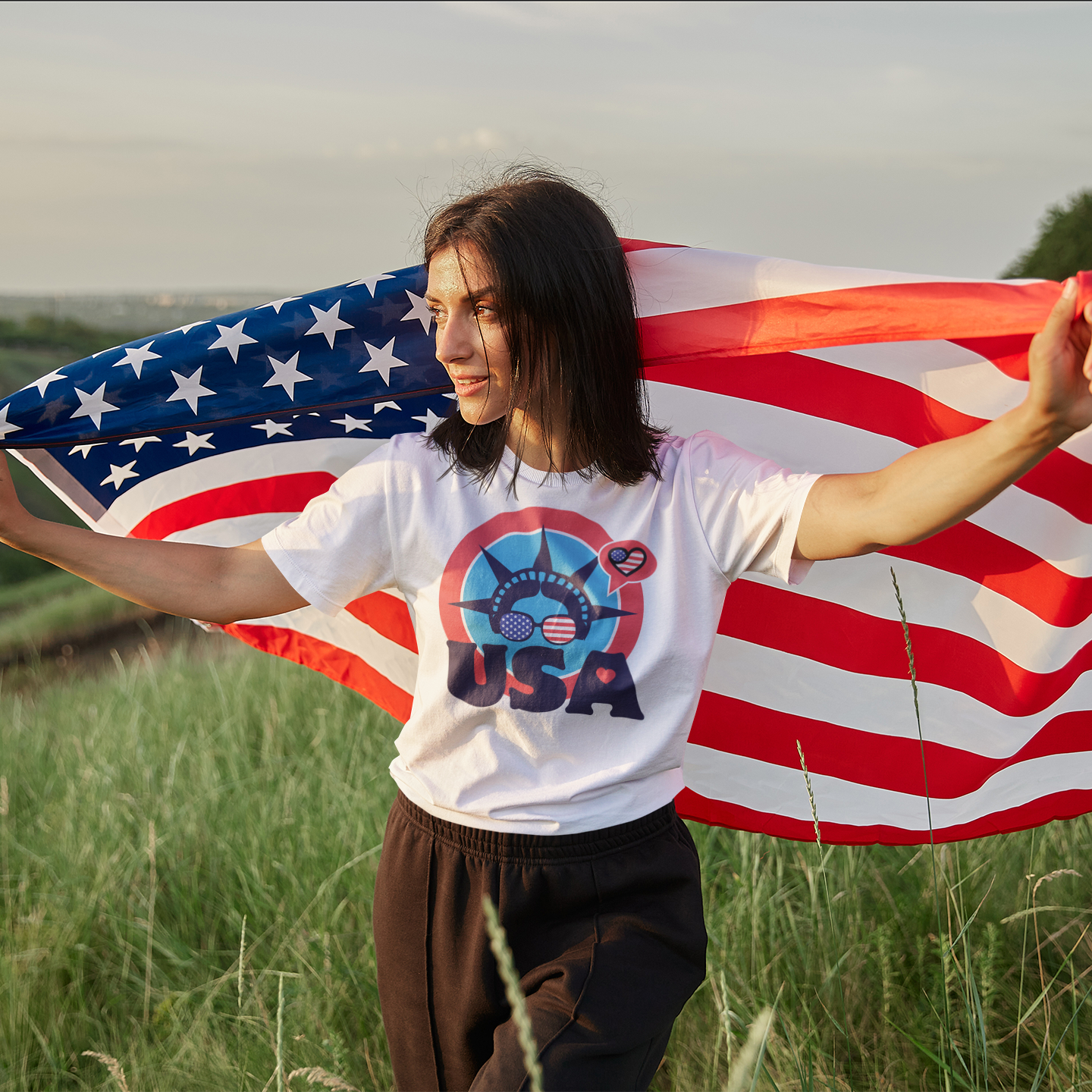 a woman holding an american flag in a field