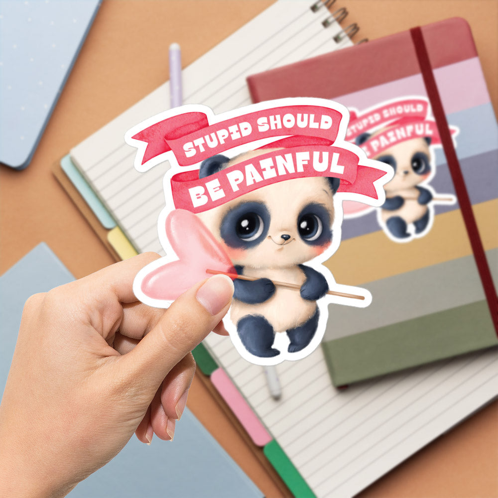 A hand is holding a sticker with a cartoon panda bear and the text "STUPID SHOULD BE PAINFUL" written on it.