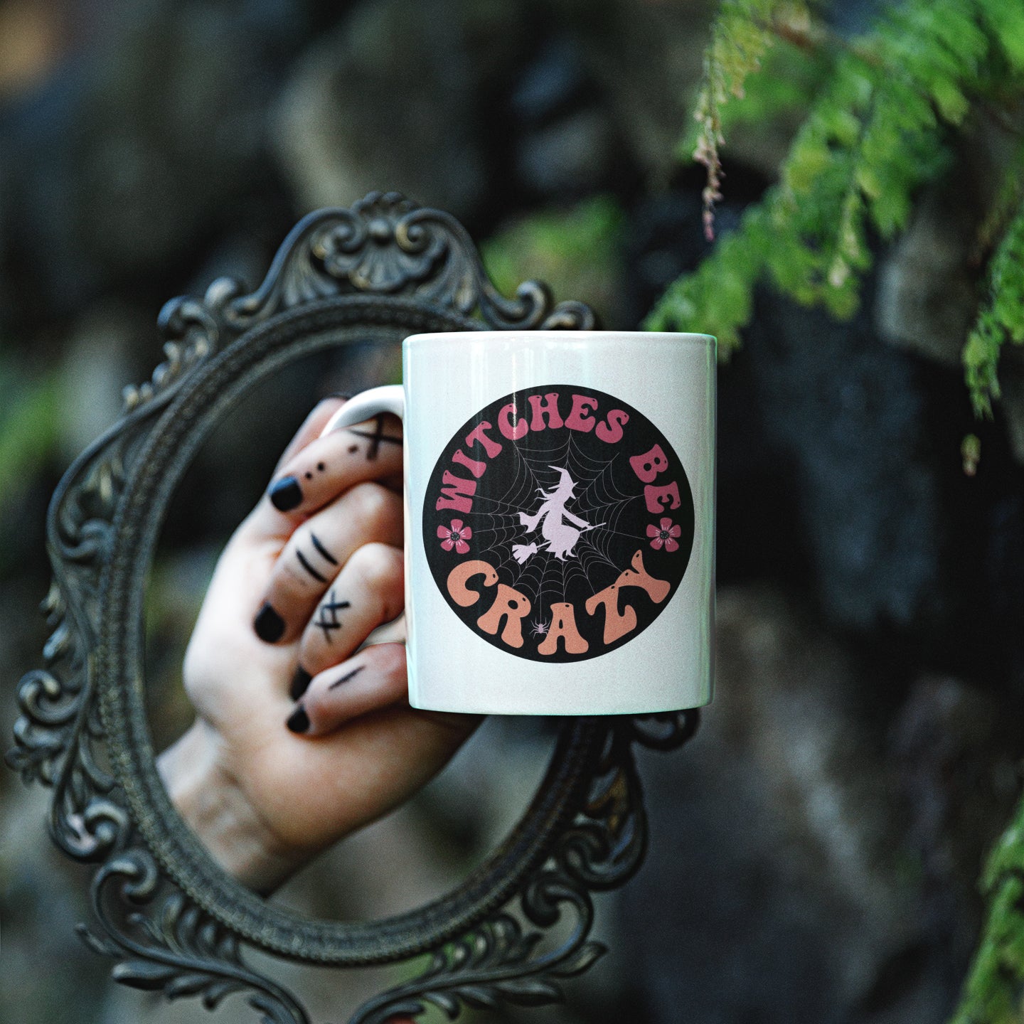 a woman's hand holding a coffee mug in front of a mirror