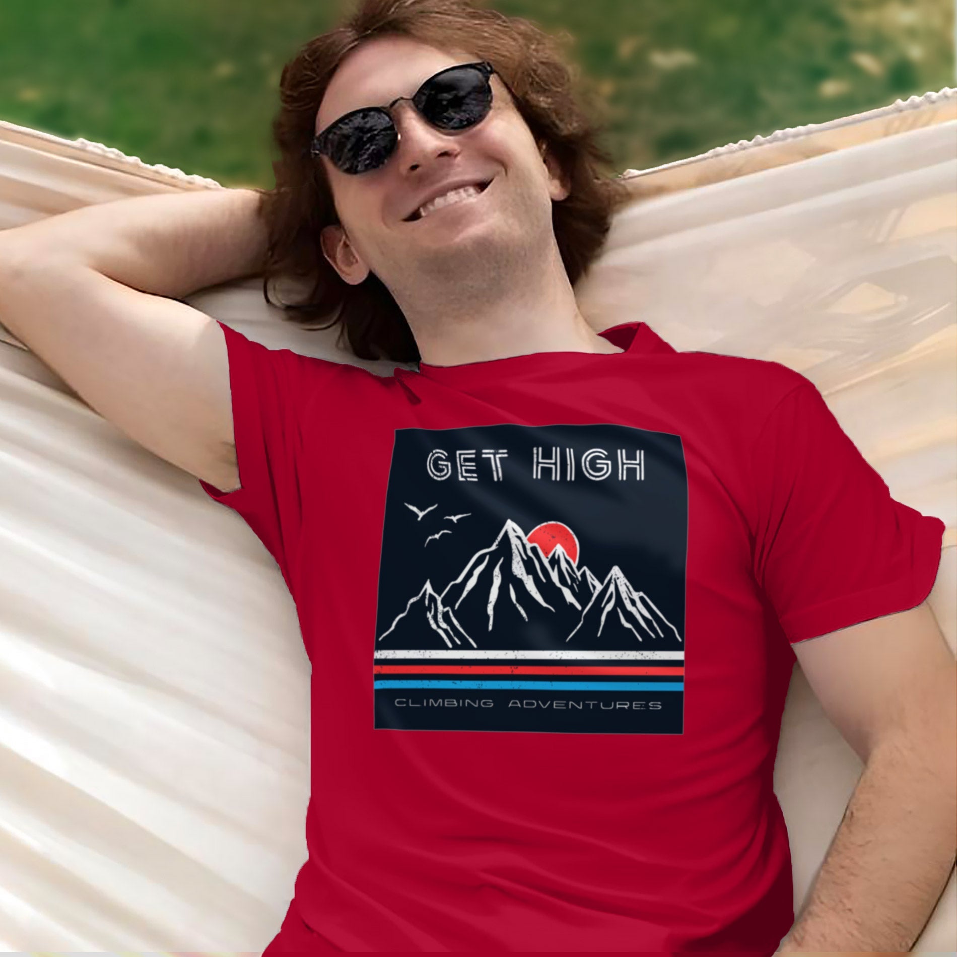 a man laying in a hammock wearing a red shirt