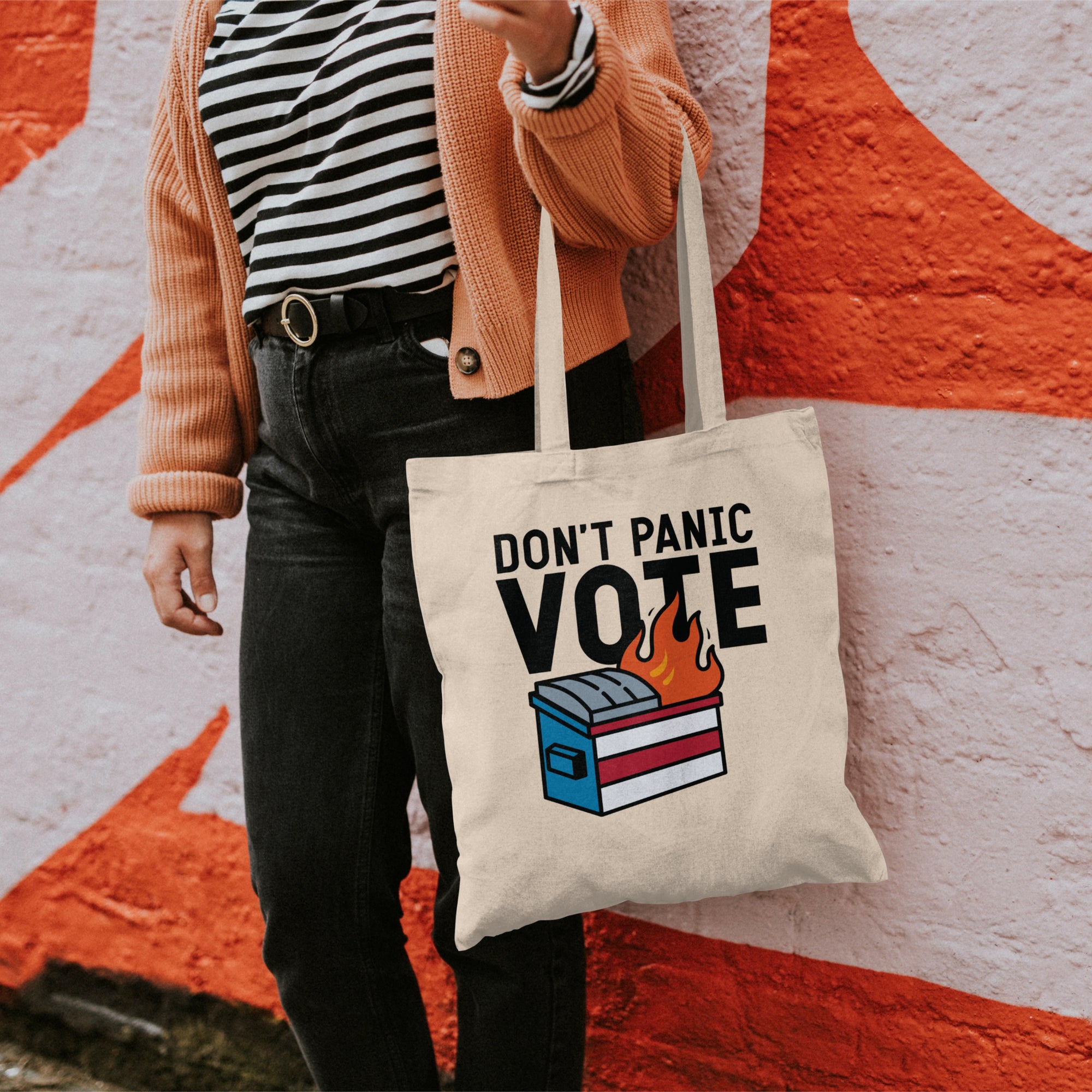 a woman holding a tote bag that says don't panic vote