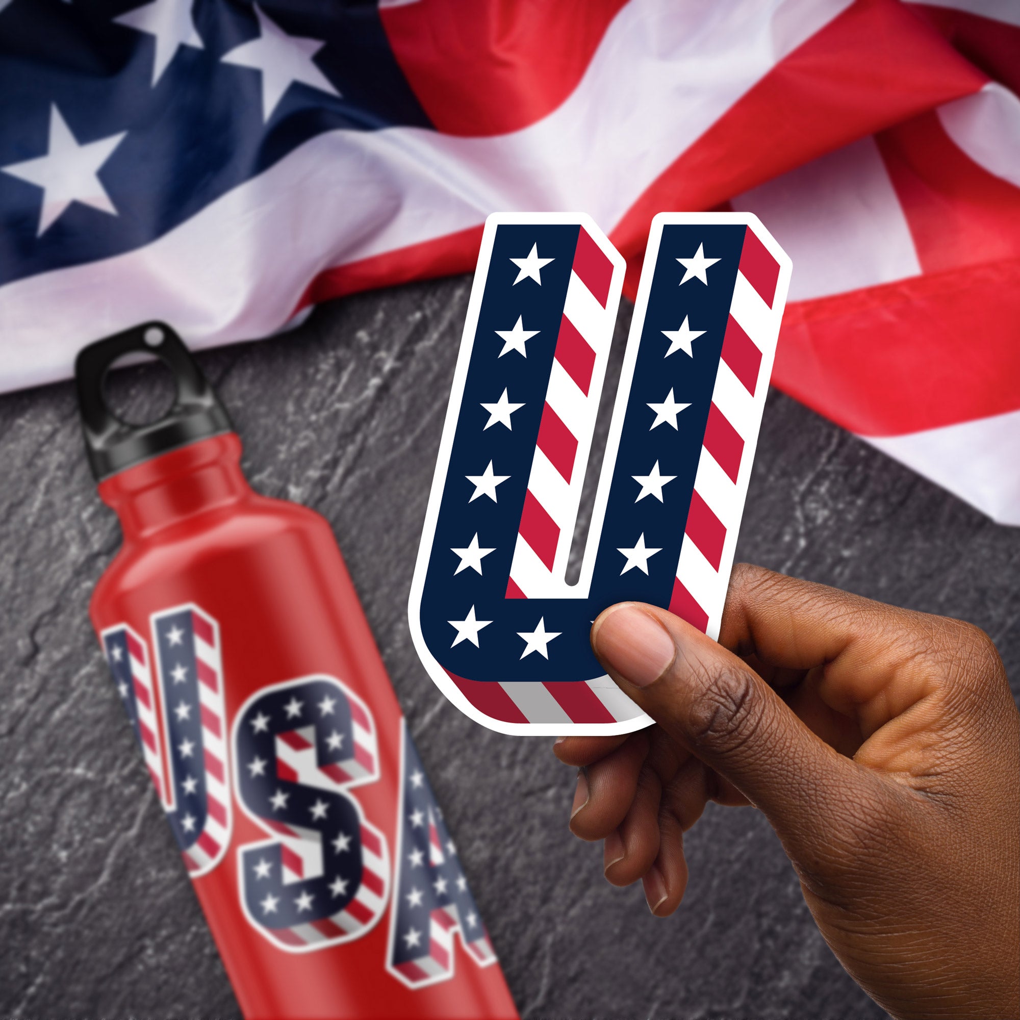 a person holding a sticker with the letter u in front of an american flag