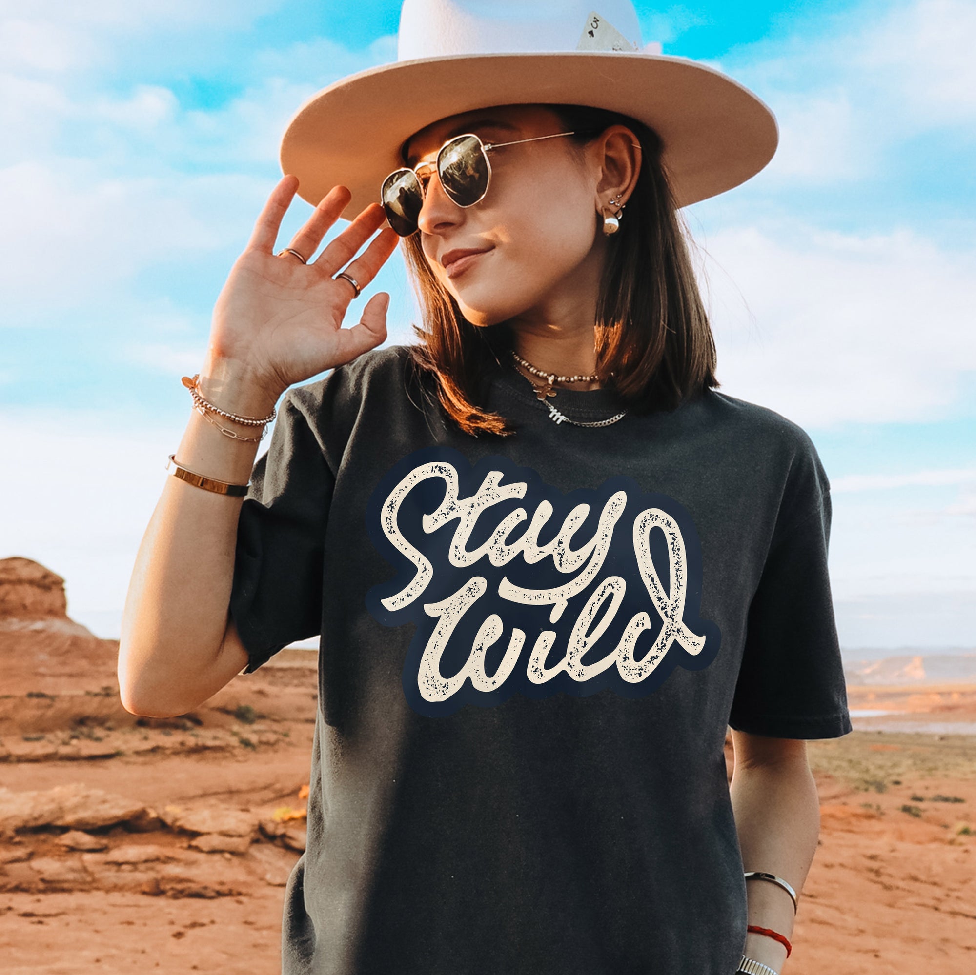 a woman wearing a hat and sunglasses in the desert