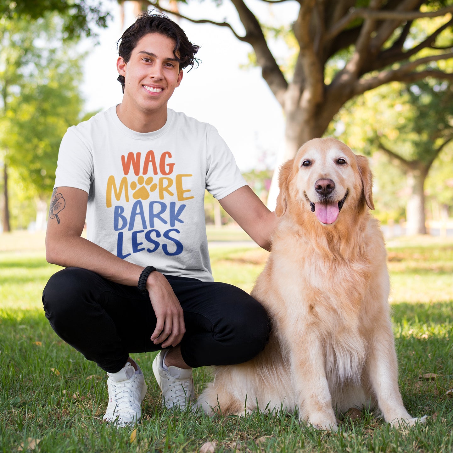 a man sitting in the grass with his dog