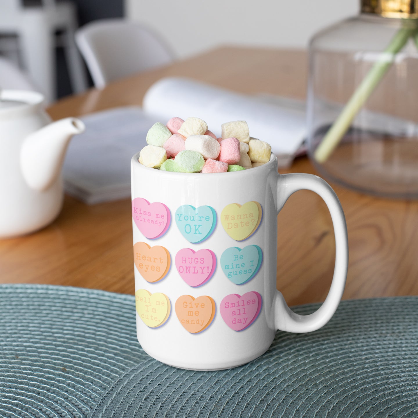 a coffee mug filled with conversation hearts on a table