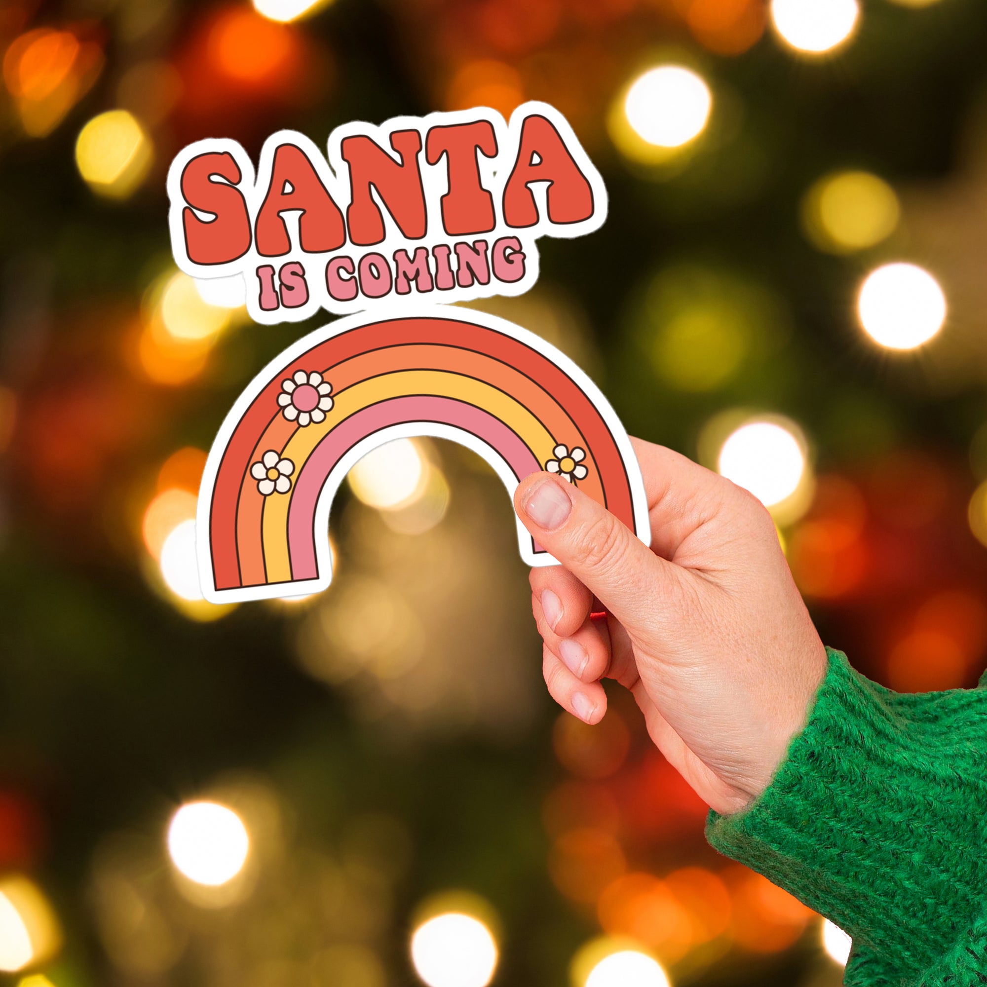 a hand holding a sticker that says santa is coming