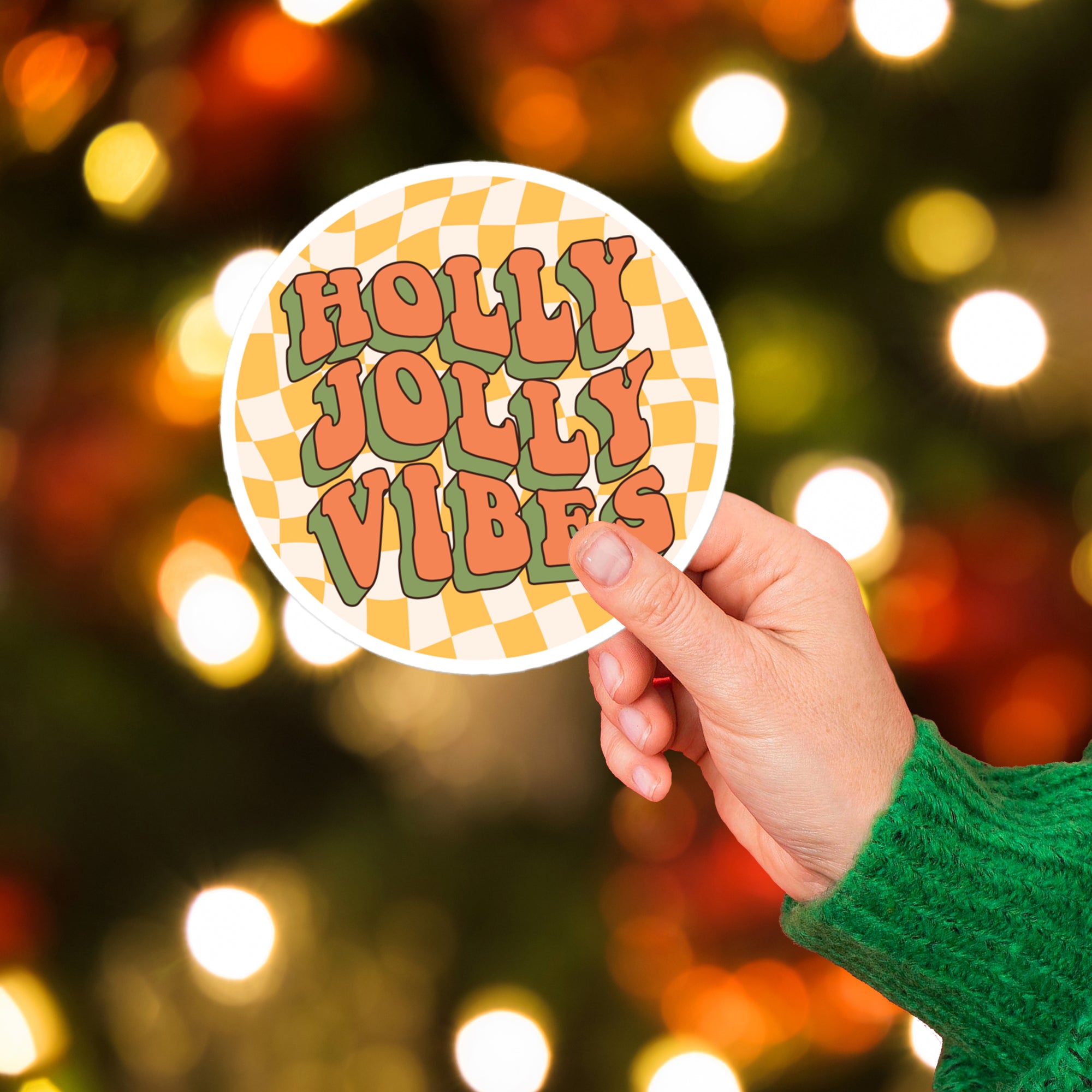 a hand holding a sticker that says holly jolly vibes