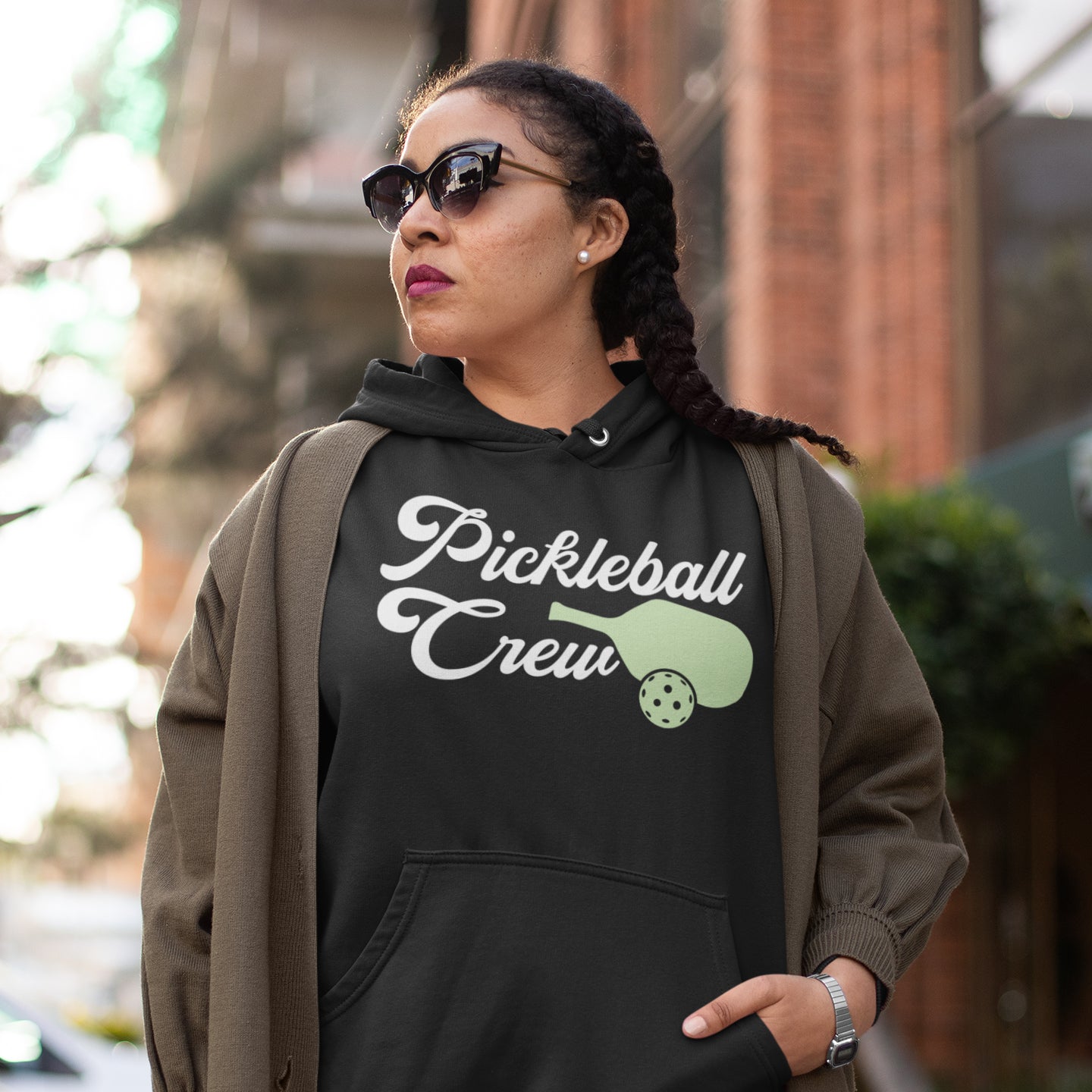 a woman wearing a black sweatshirt with a pickleball crew on it