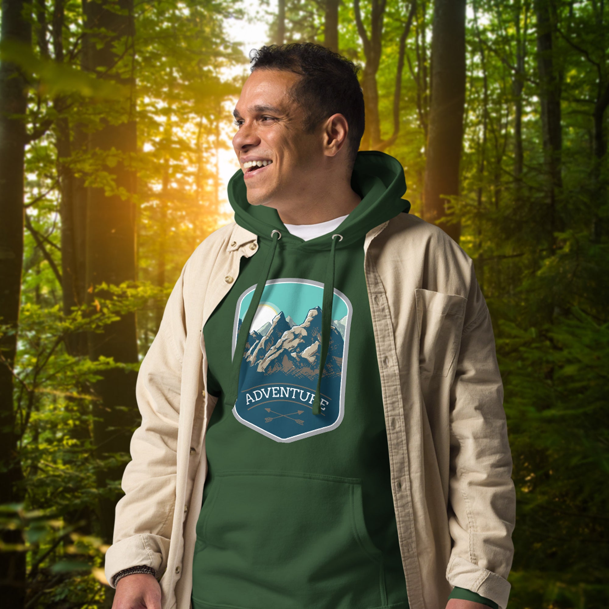 a man in a hoodie standing in the woods