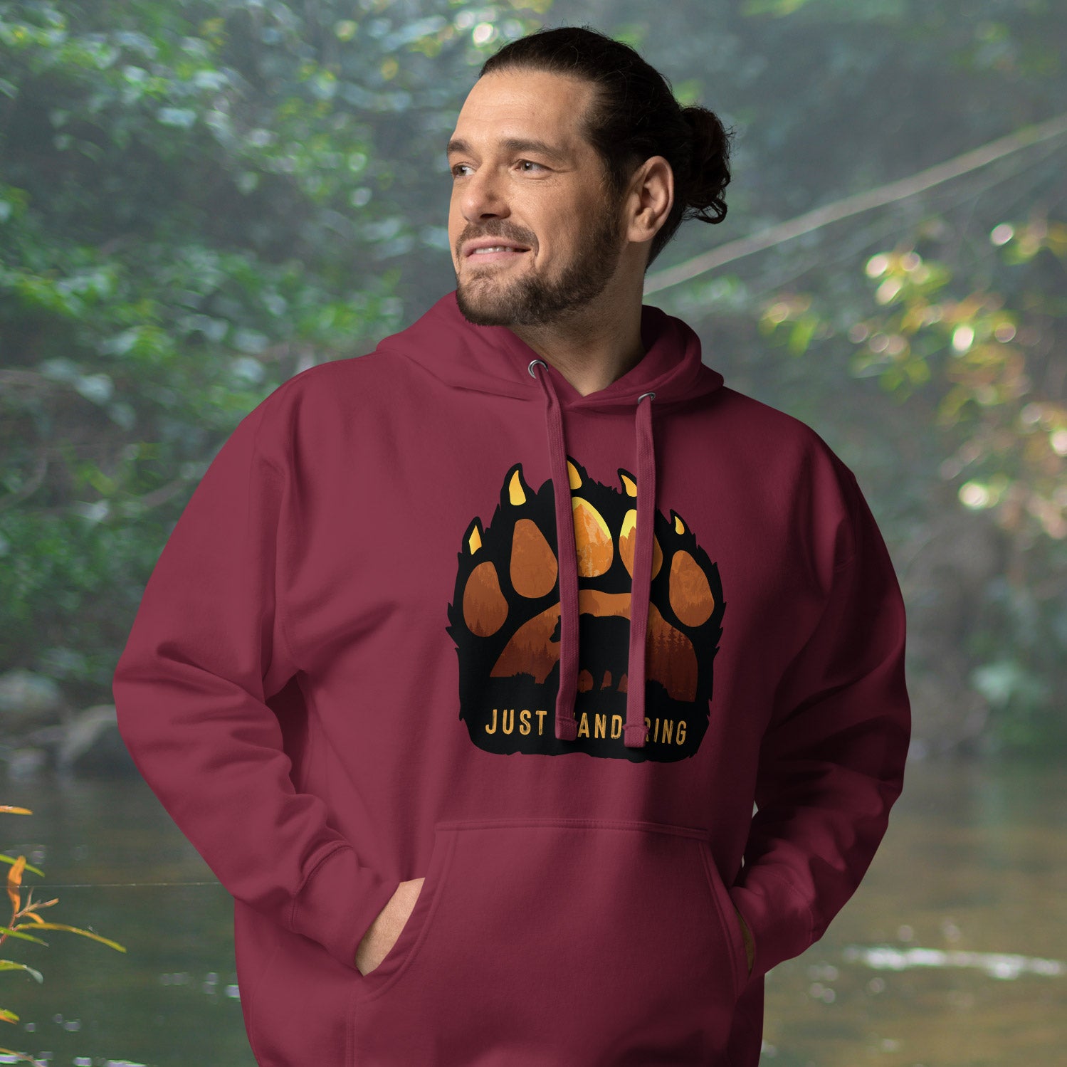 a man wearing a maroon hoodie with a bear paw on it