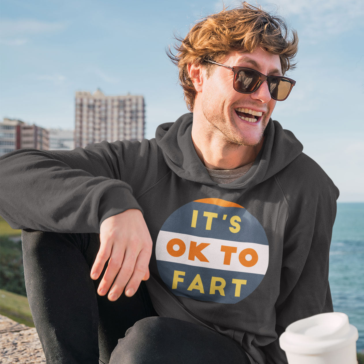 a man wearing a sweatshirt that says it's ok to far