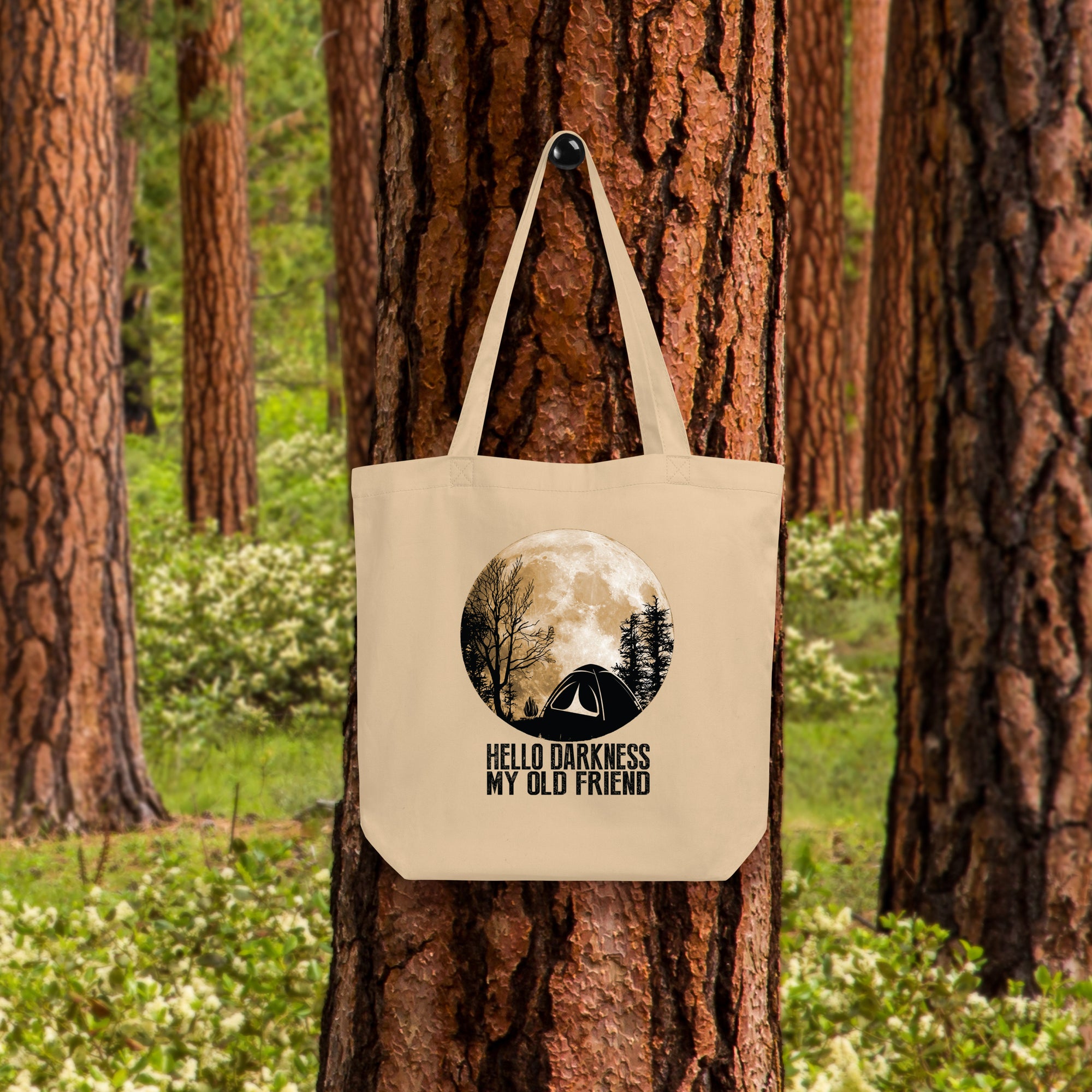 a tote bag hanging on a tree in a forest