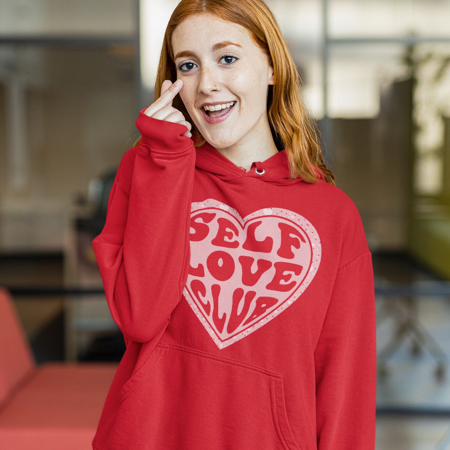 a woman in a red hoodie talking on a cell phone