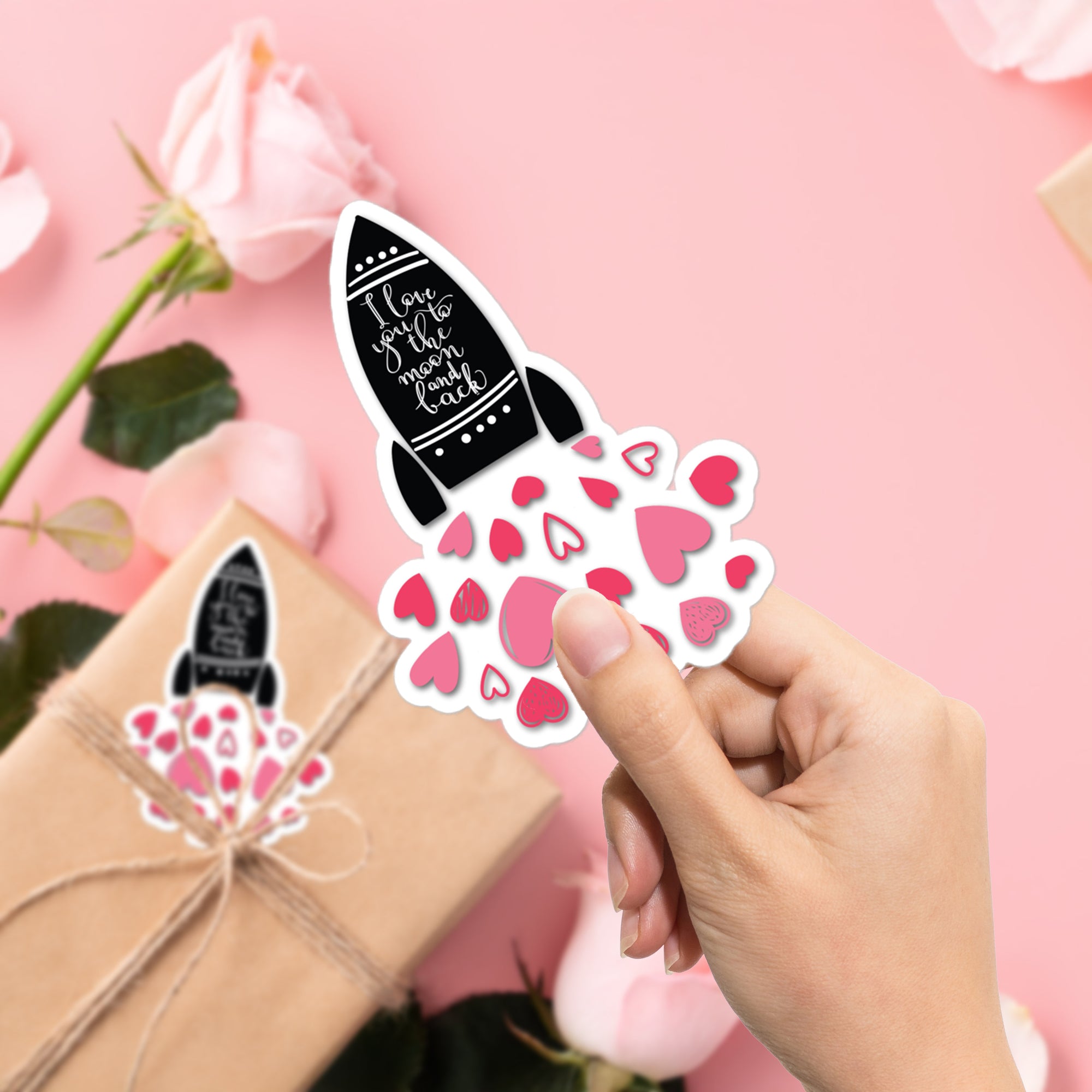 a person holding up a sticker with hearts on it
