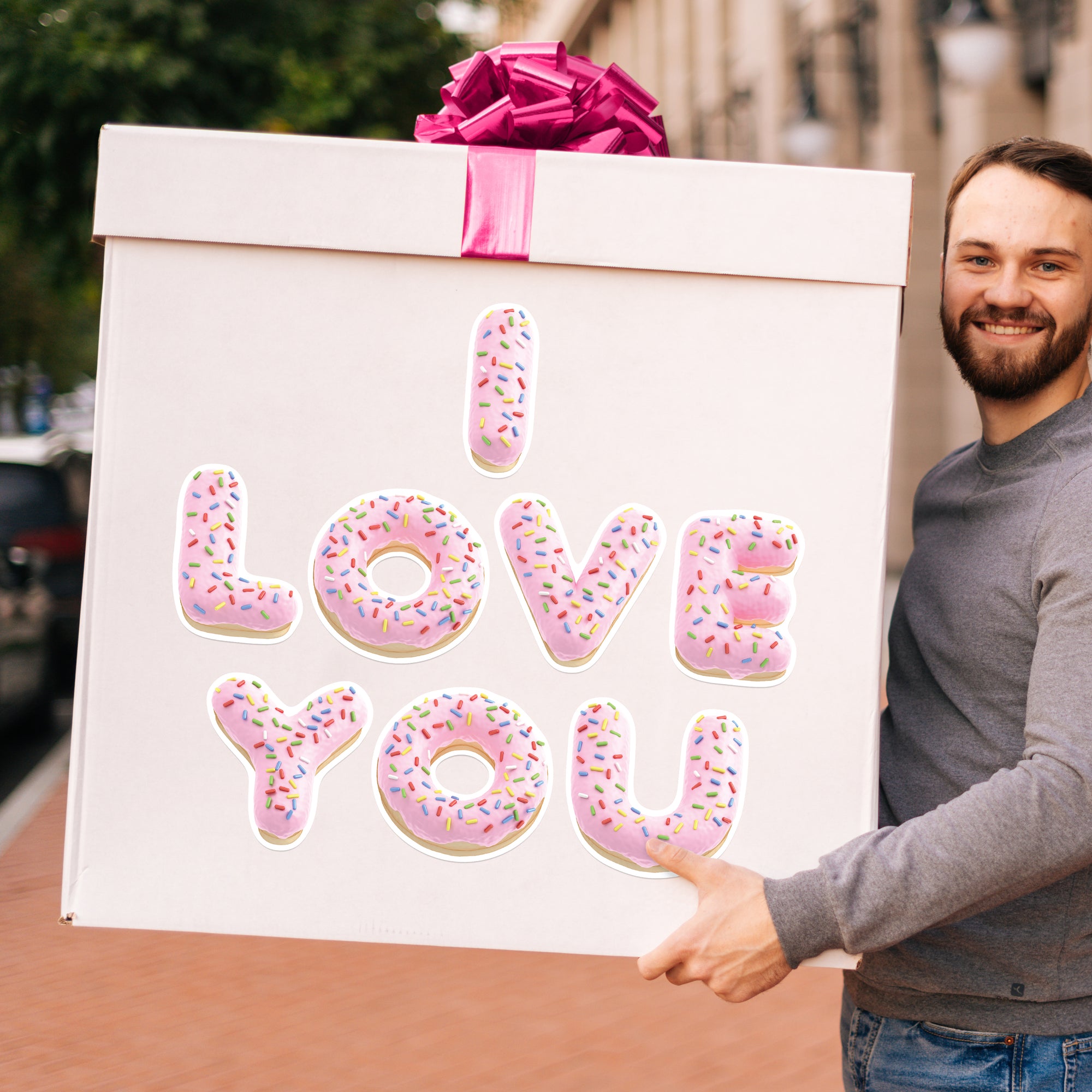 a man holding a box with donuts on it