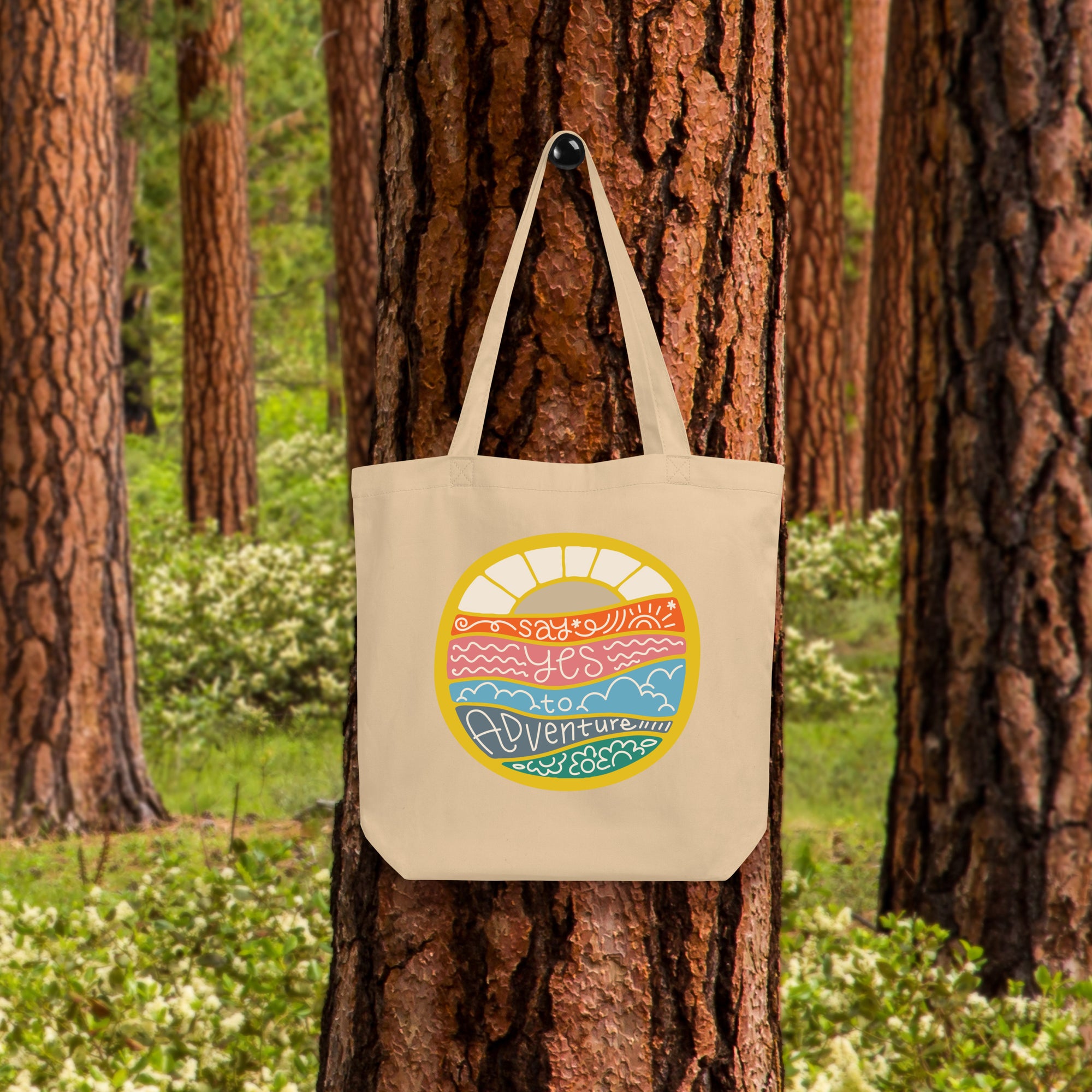 a tote bag hanging on a tree in a forest