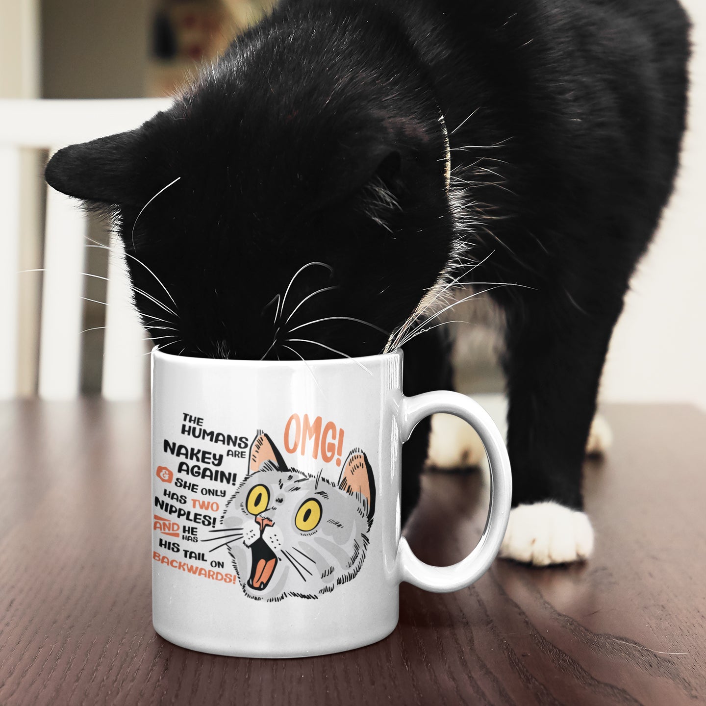 a black and white cat drinking out of a coffee cup