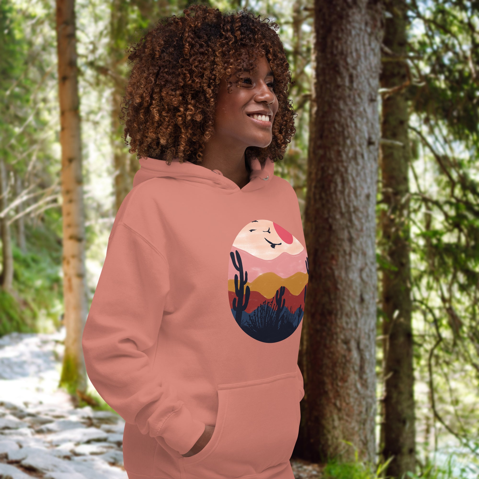 a woman wearing a pink hoodie in the woods