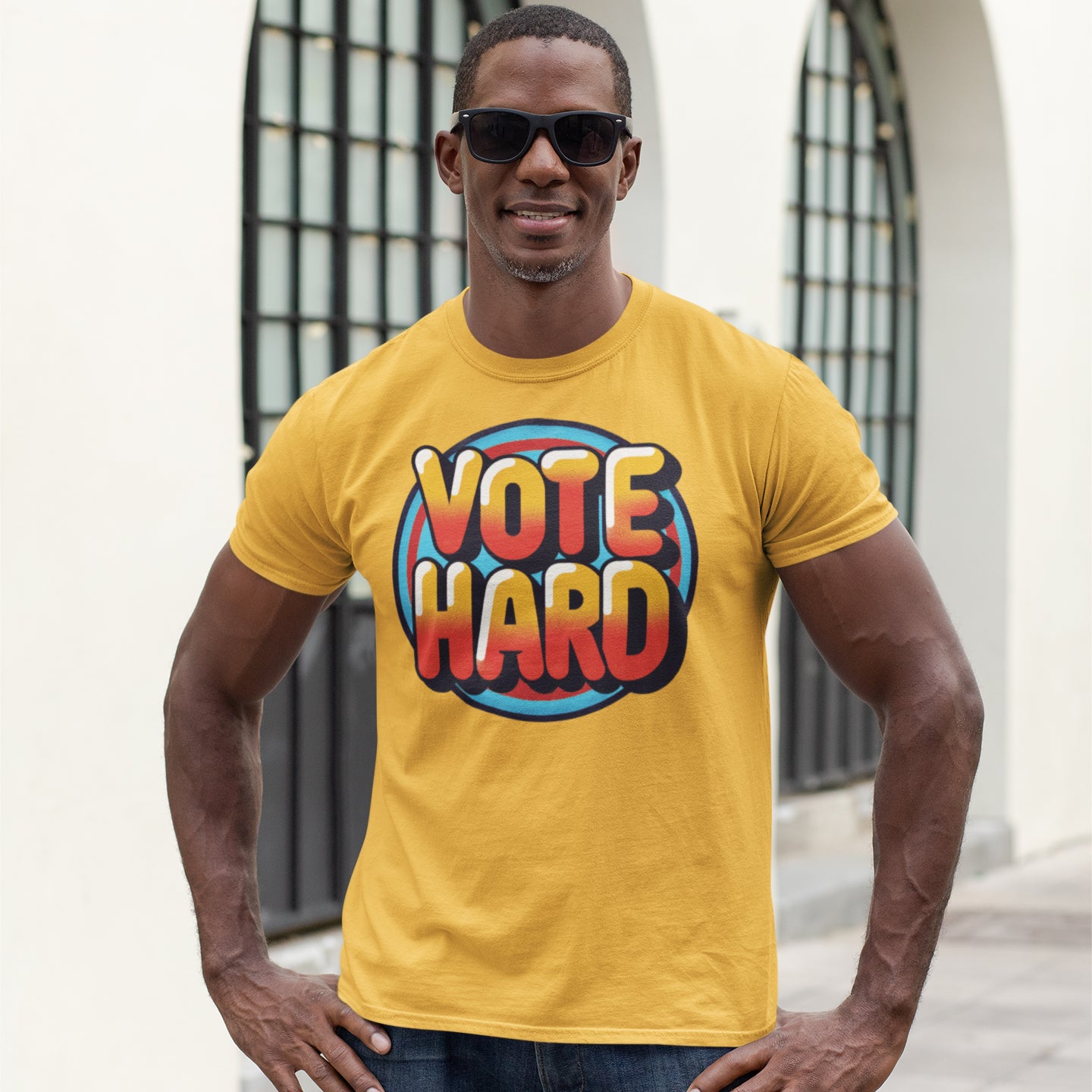 a man wearing a vote hard t - shirt standing in front of a building