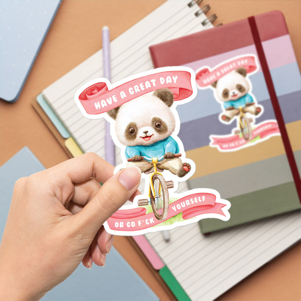 A hand is holding a sticker featuring a panda riding a bicycle, with a banner that says "Have a great day" and "Or go F*CK yourself".