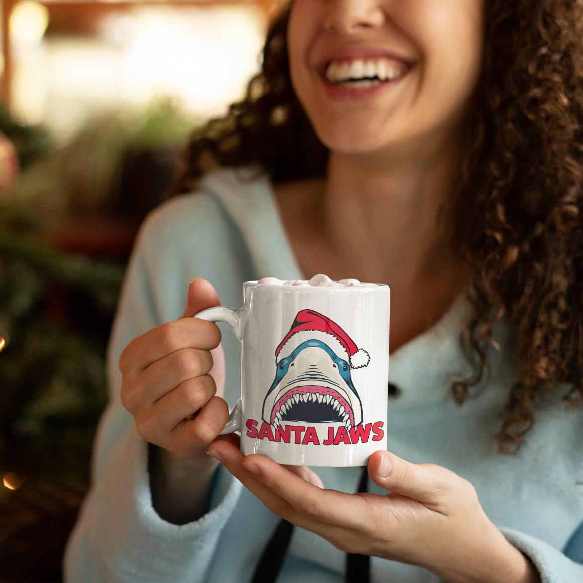 a woman holding a coffee mug with a shark on it