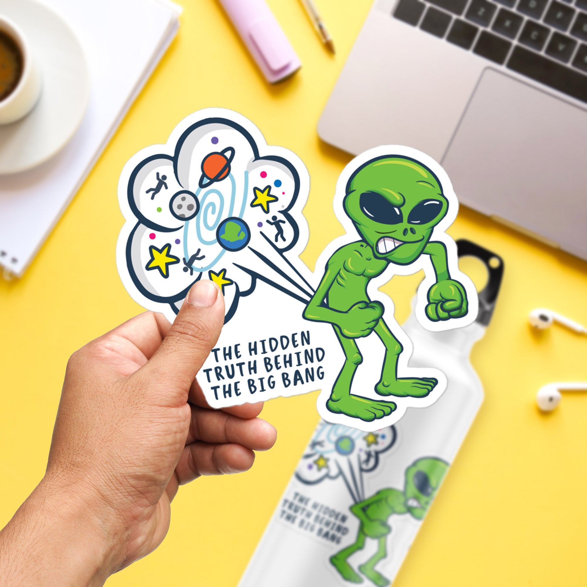 a hand holding a sticker of an alien
