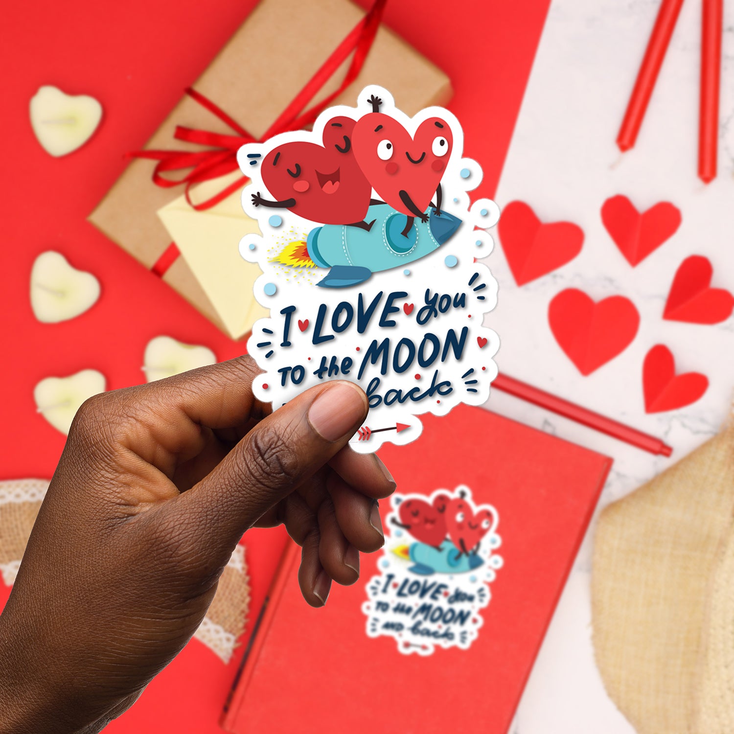 a hand holding a sticker that says i love you to the moon and back